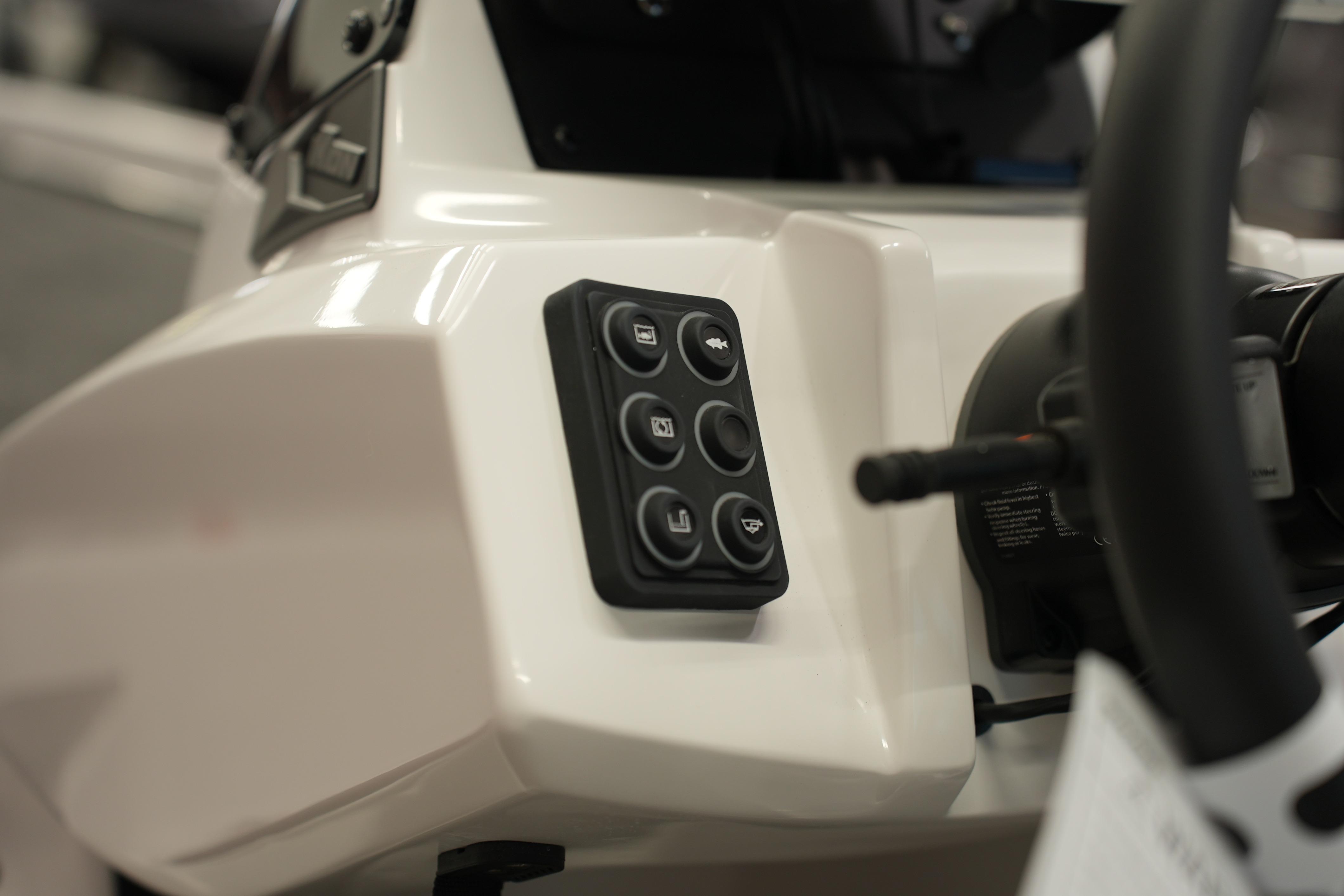Control panel of 2026 iKon VLE21 boat, featuring multiple buttons and steering wheel.