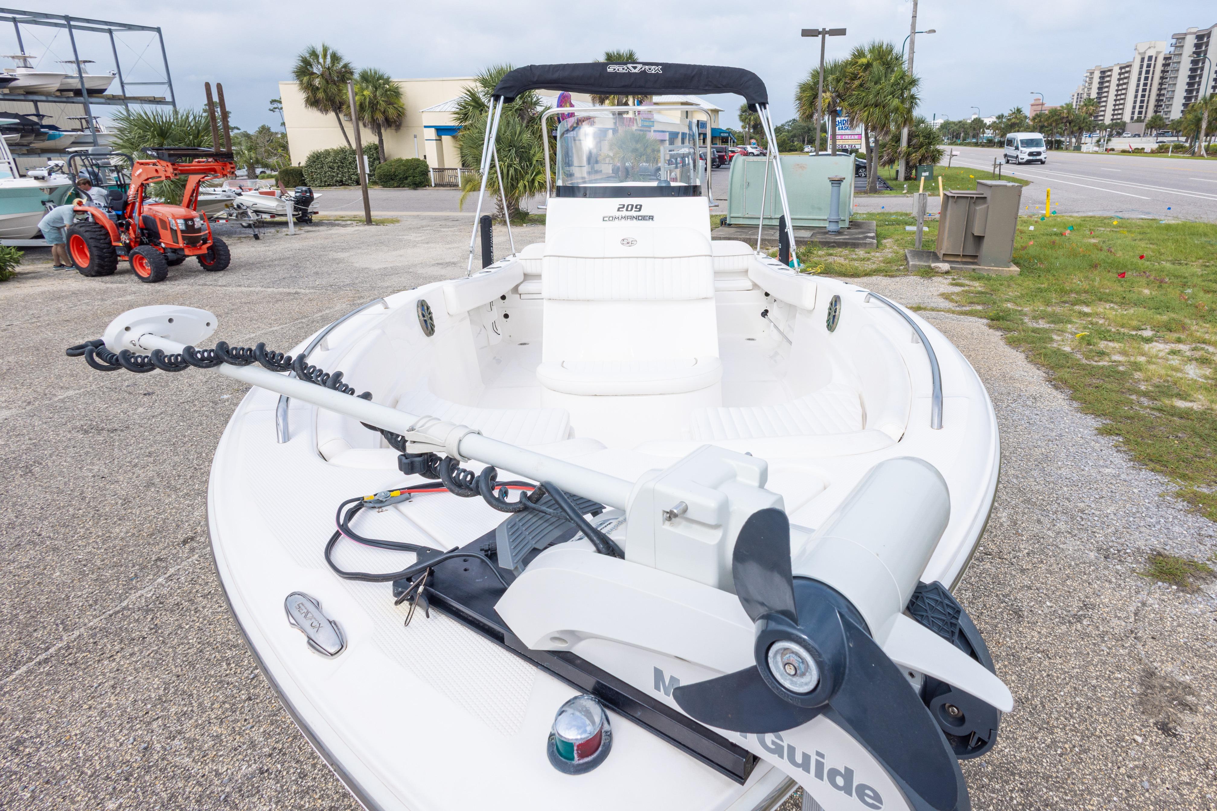 2014 Sea Fox 209 Commander boat with trolling motor, parked outdoors.