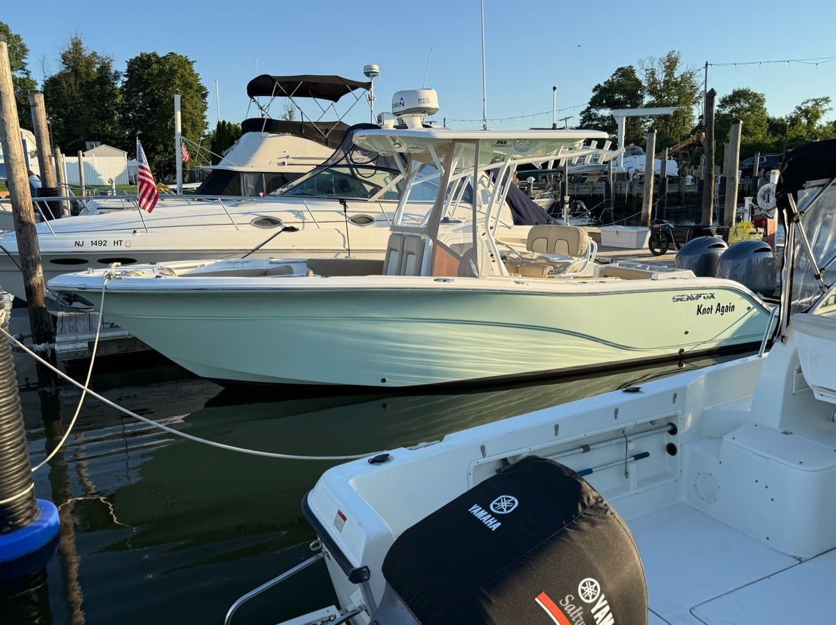 A 2017 Sea Fox Commander 266 docked at a marina, surrounded by other boats.