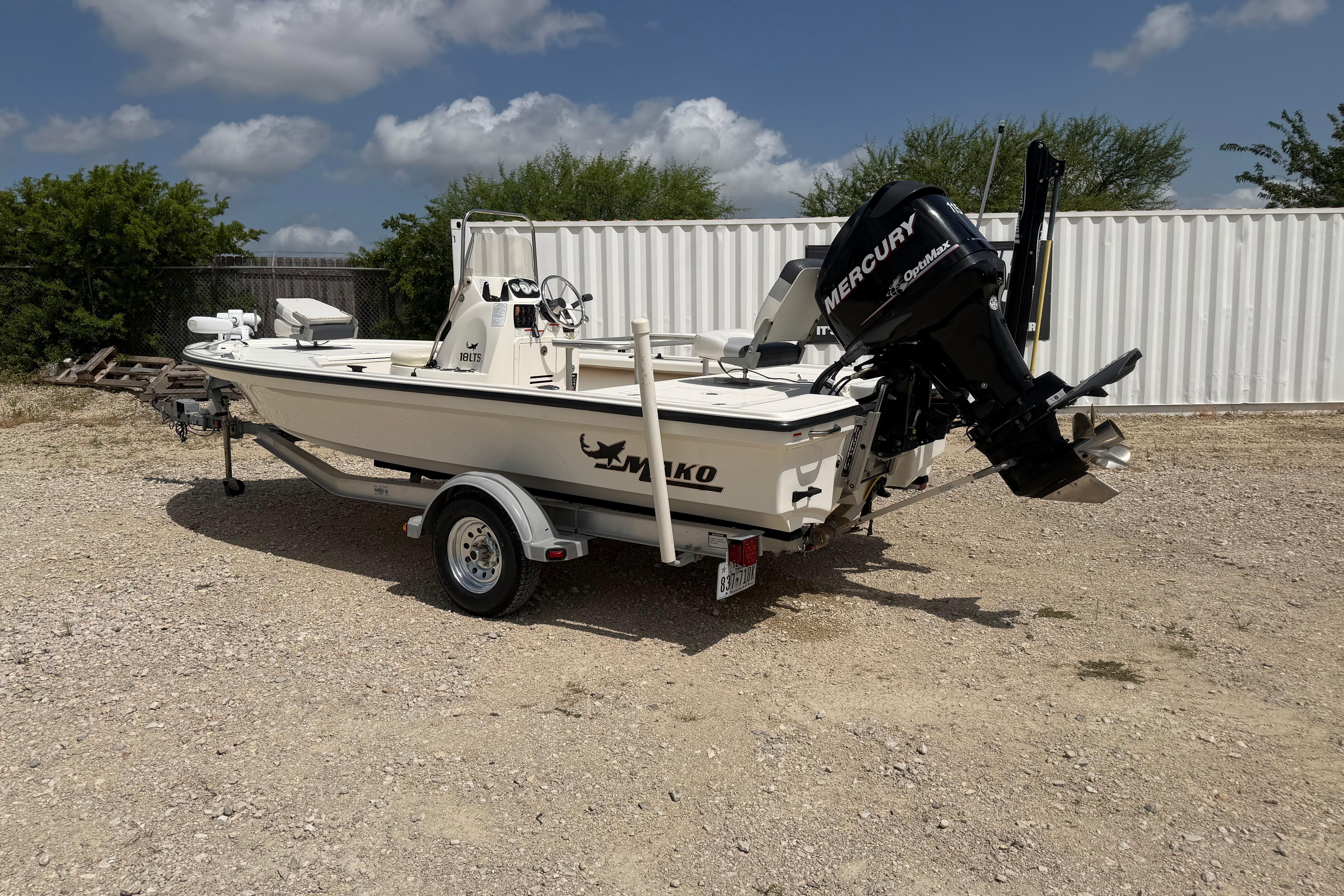 2012 Mako 18 LTS boat with Mercury engine on trailer, parked outdoors.