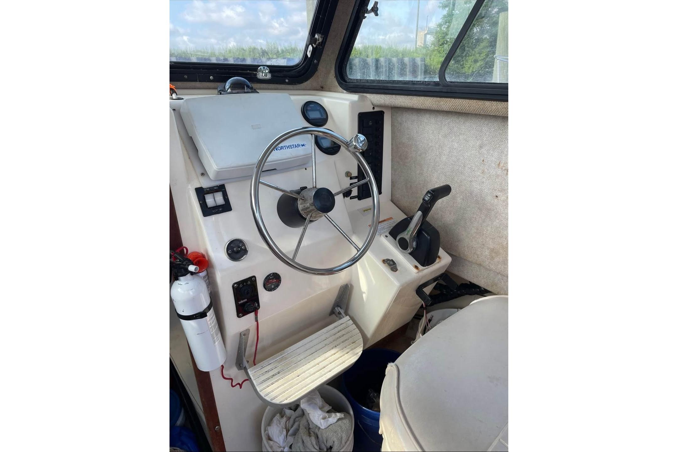 Helm of 2002 Parker 2520 Deep Vee Sport Cabin boat with steering wheel and controls.