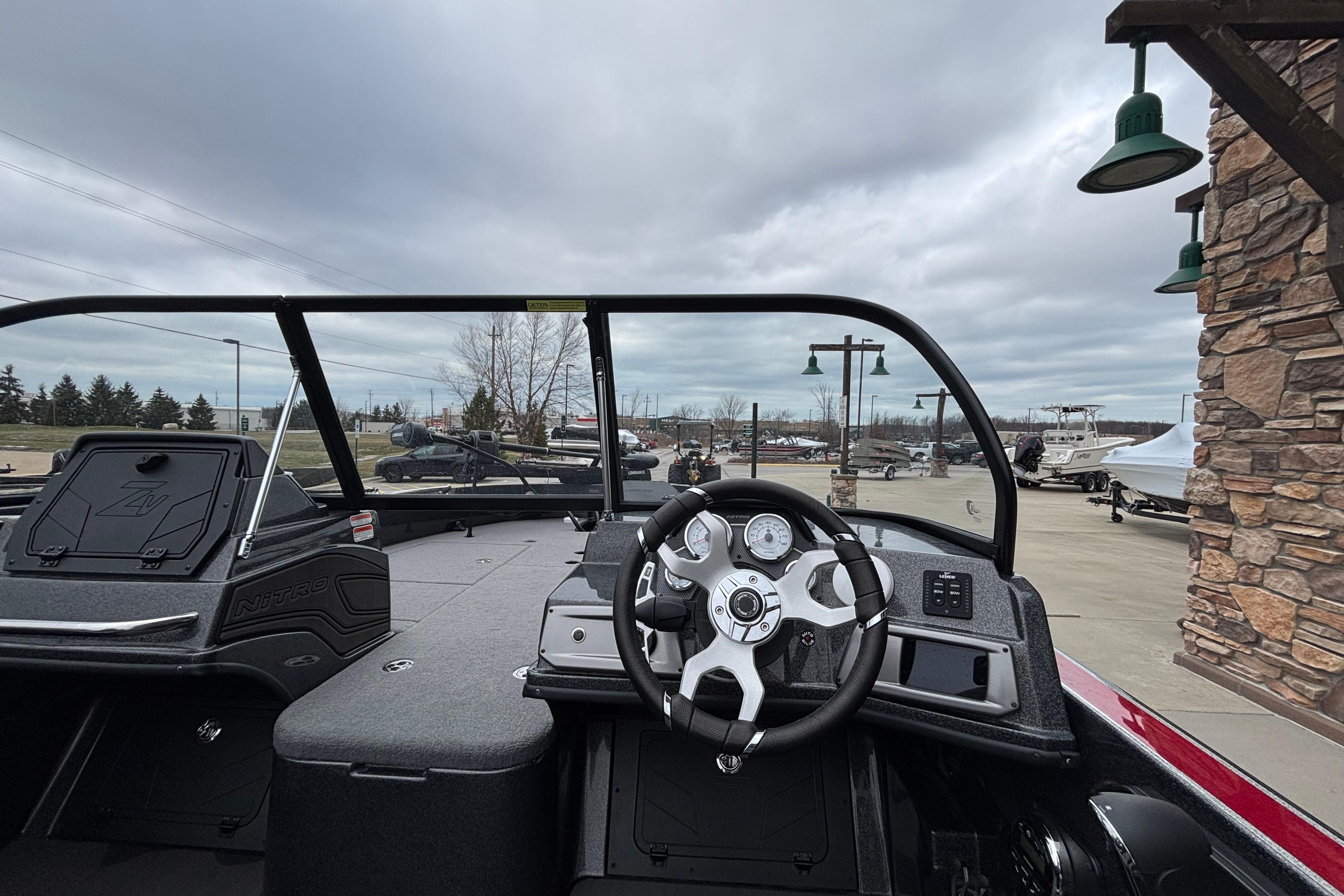 2024 Nitro ZV21 Pro boat interior with steering wheel and dashboard, parked outdoors.