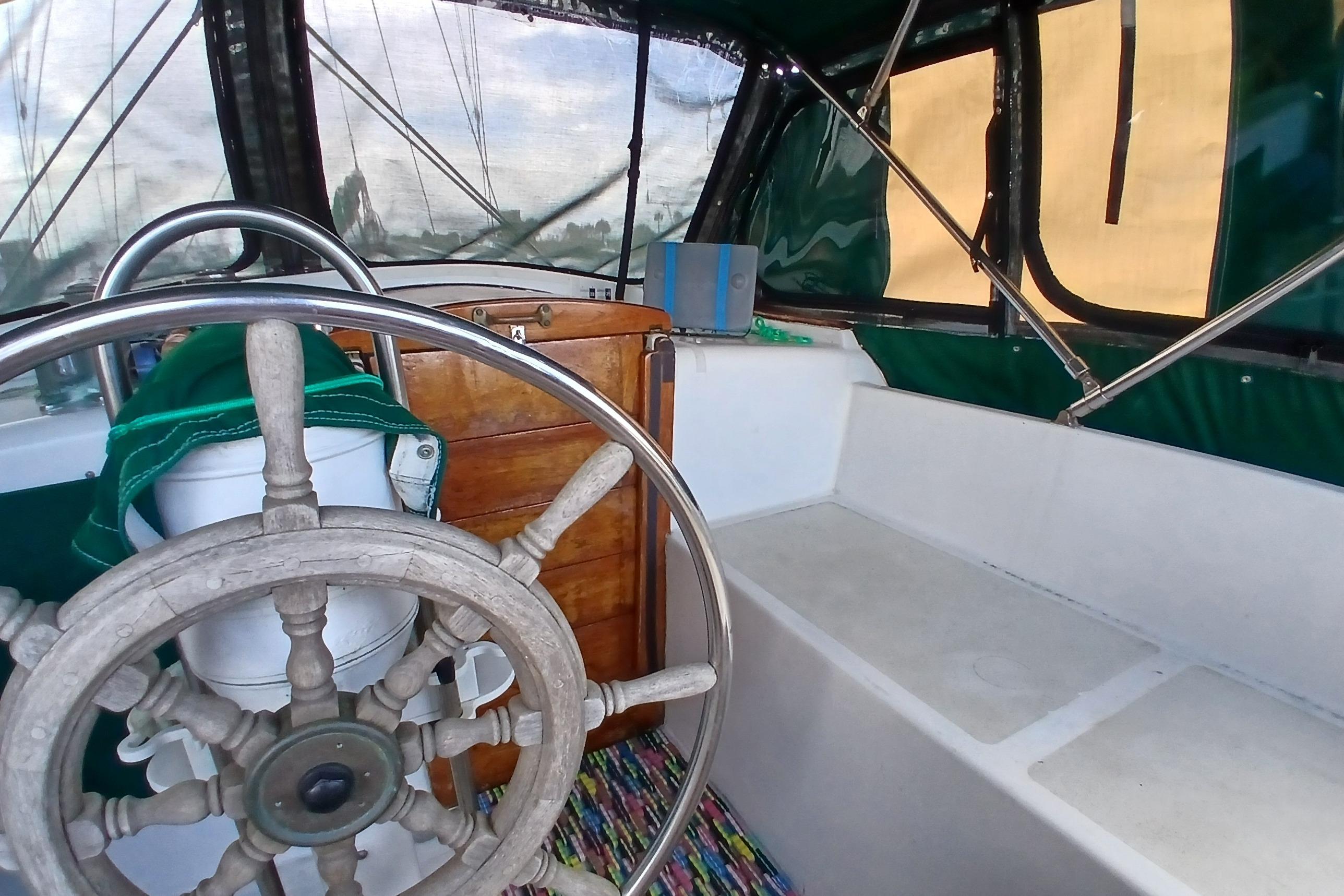 1981 Wellington 44 Center Cockpit interior with wooden helm and green canopy.