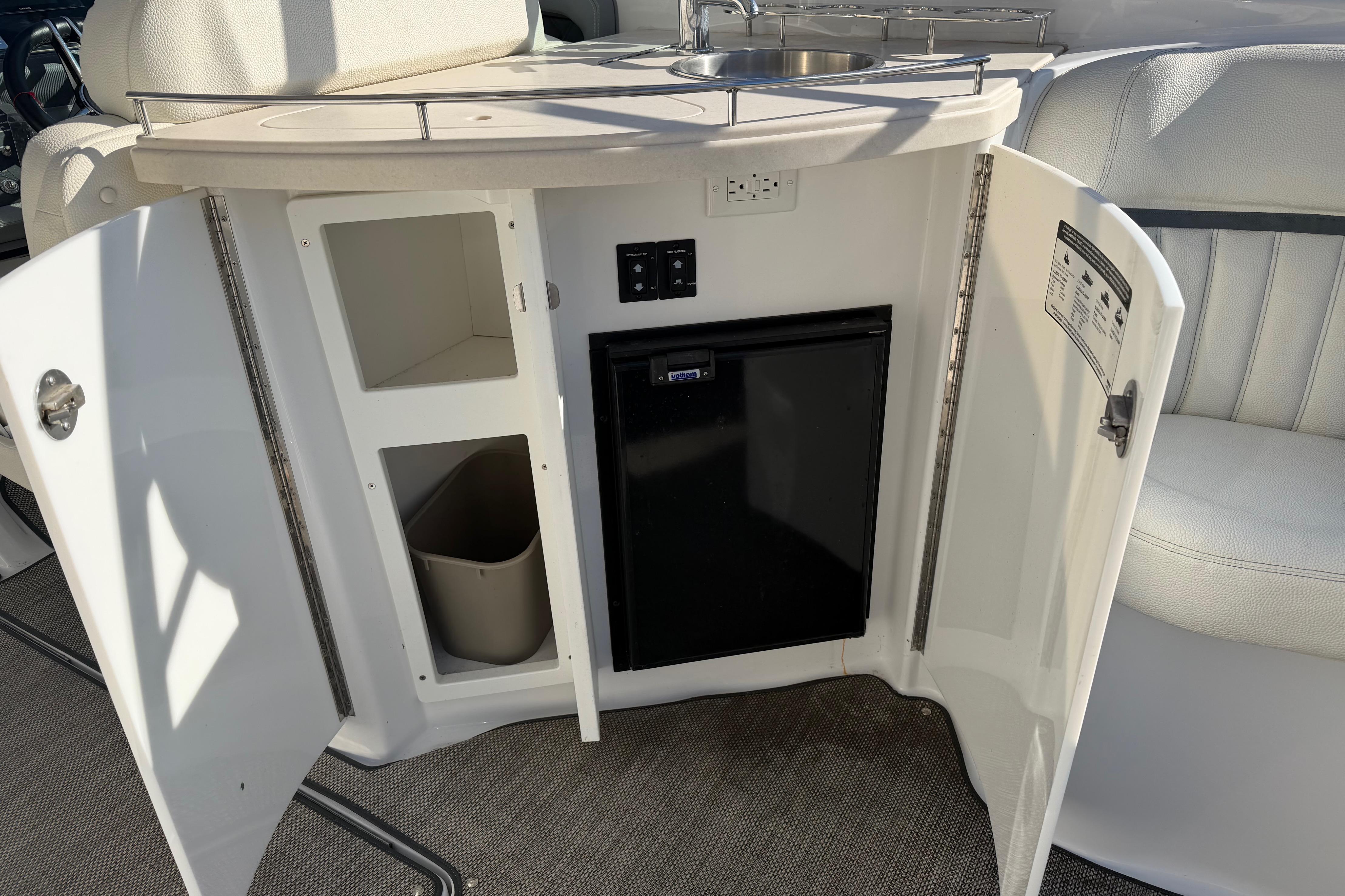 2019 Cobalt R35 boat interior with open cabinet, mini fridge, and sink.