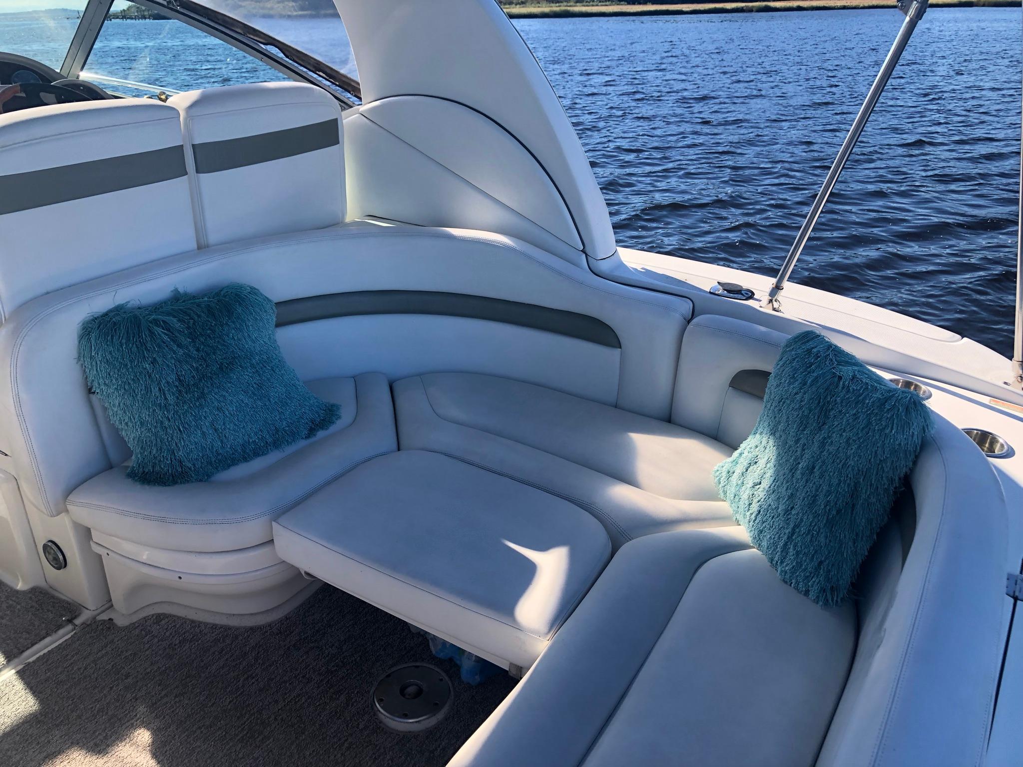 2006 Sea Ray 320 Sundancer boat interior with plush seating and teal cushions on the water.