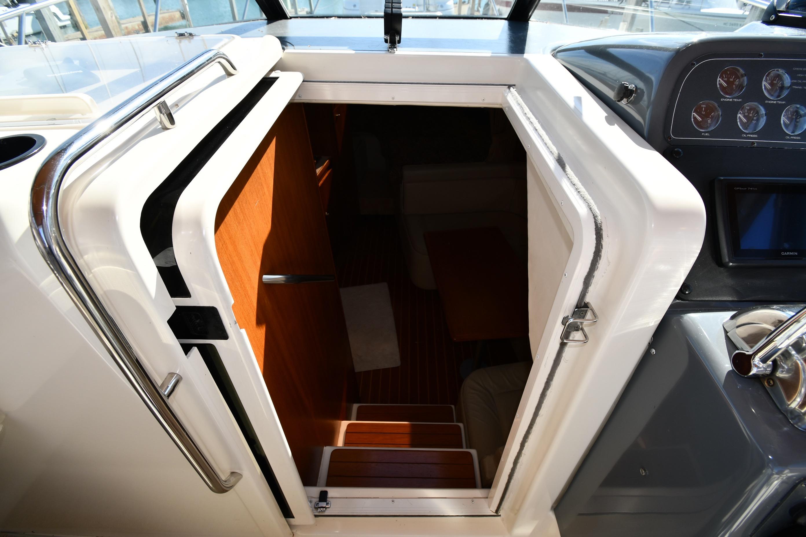 Cabin entrance of 1998 Tiara Yachts 3100 Open, featuring wooden steps and sleek interior design.