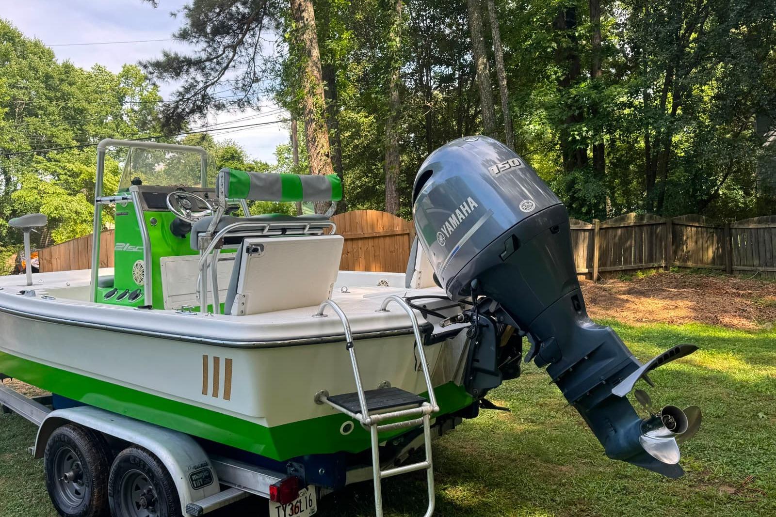 2016 Epic 21 Sport Console boat with Yamaha motor on trailer in a yard.