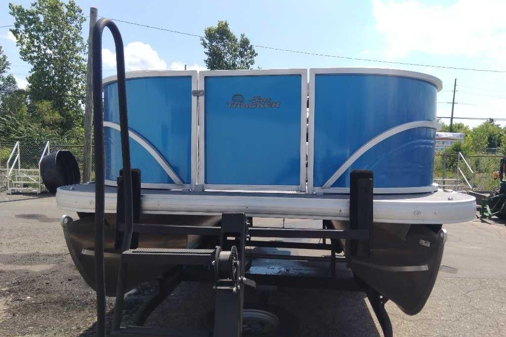 2026 Sun Tracker Party Barge 16 DLX pontoon boat on trailer, blue exterior.