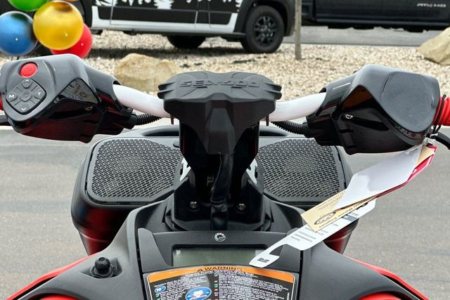 Handlebars of a Sea-Doo PWC SPARK TRIXX 90 with controls and warning labels.