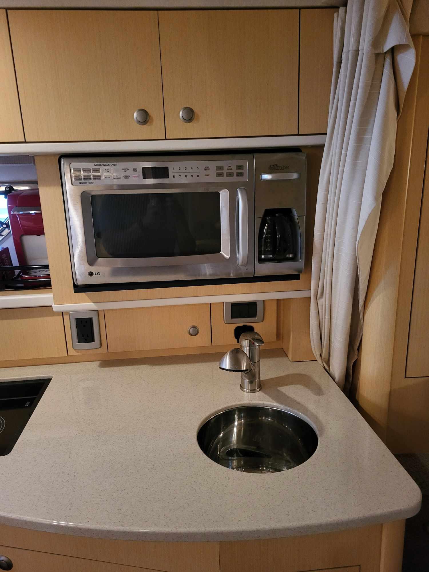 2009 Sea Ray 310 Sundancer galley with microwave, sink, and cabinetry.