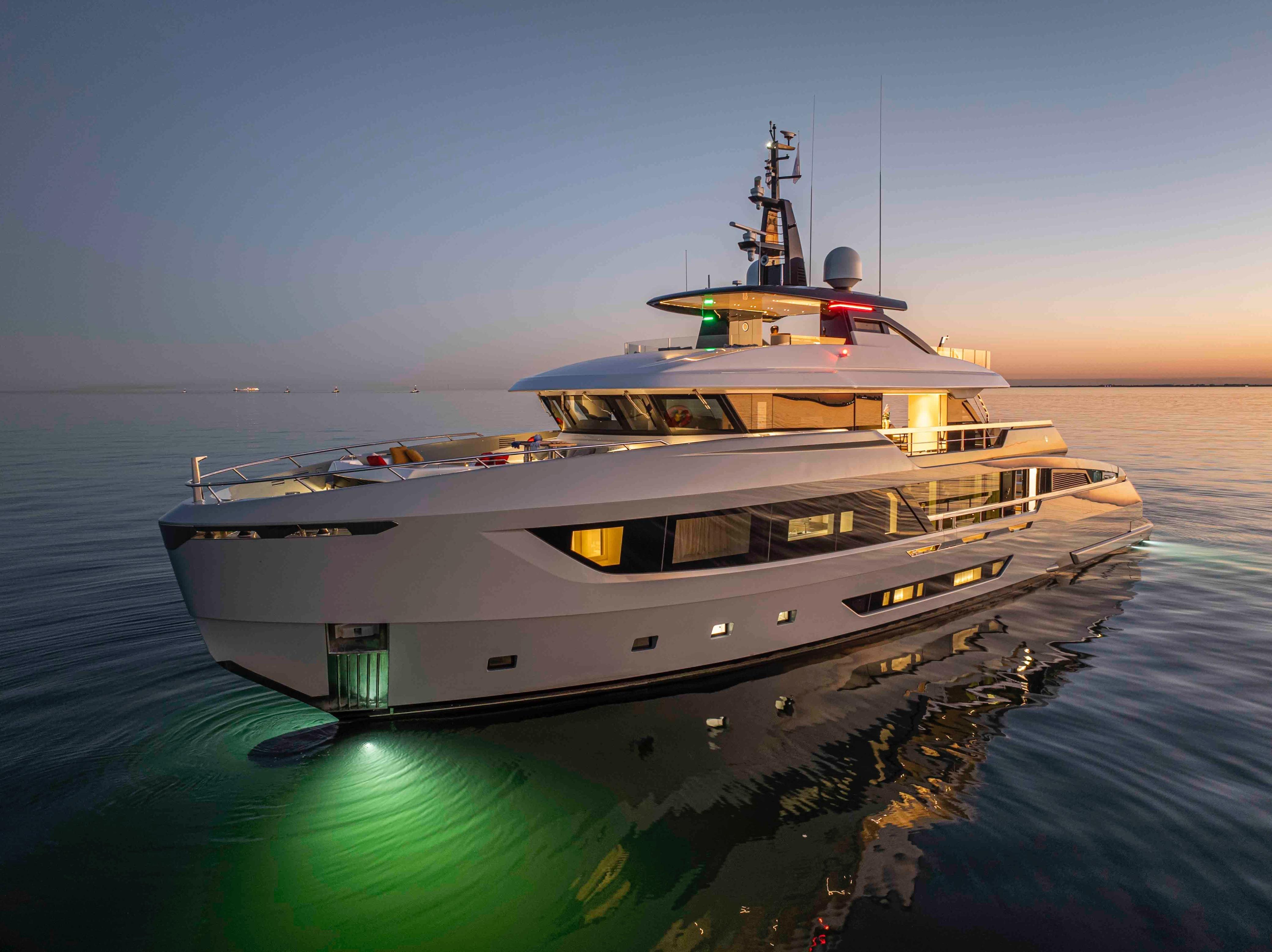 Luxurious Ocean King Doge 400 yacht, 2027 model, illuminated on calm waters at sunset.