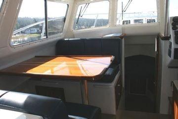 2005 Ocean Sport Roamer 30' interior with seating and table, showcasing cabin design.