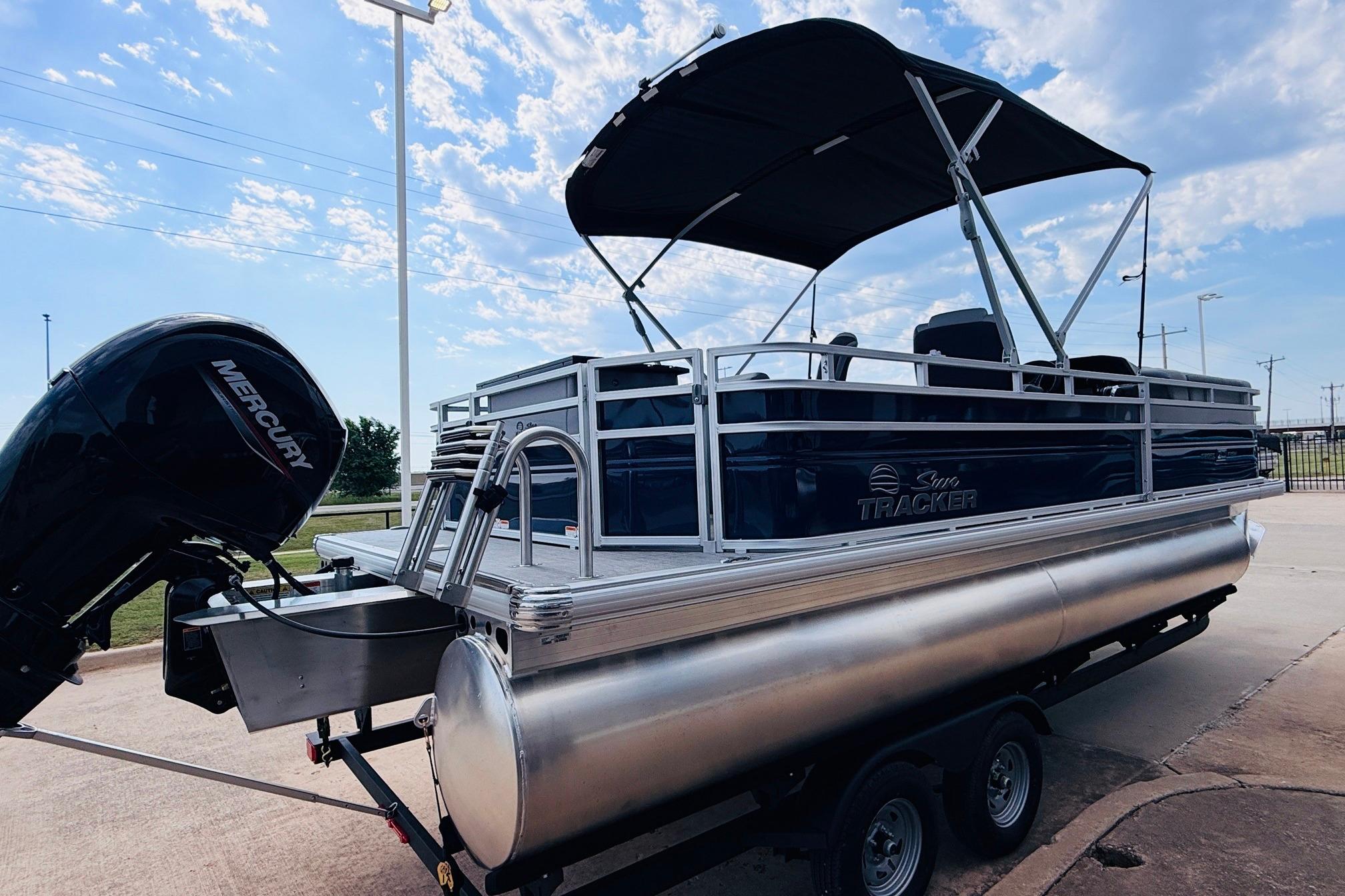 2026 Sun Tracker SportFish 22 DLX pontoon boat with Mercury engine on trailer.