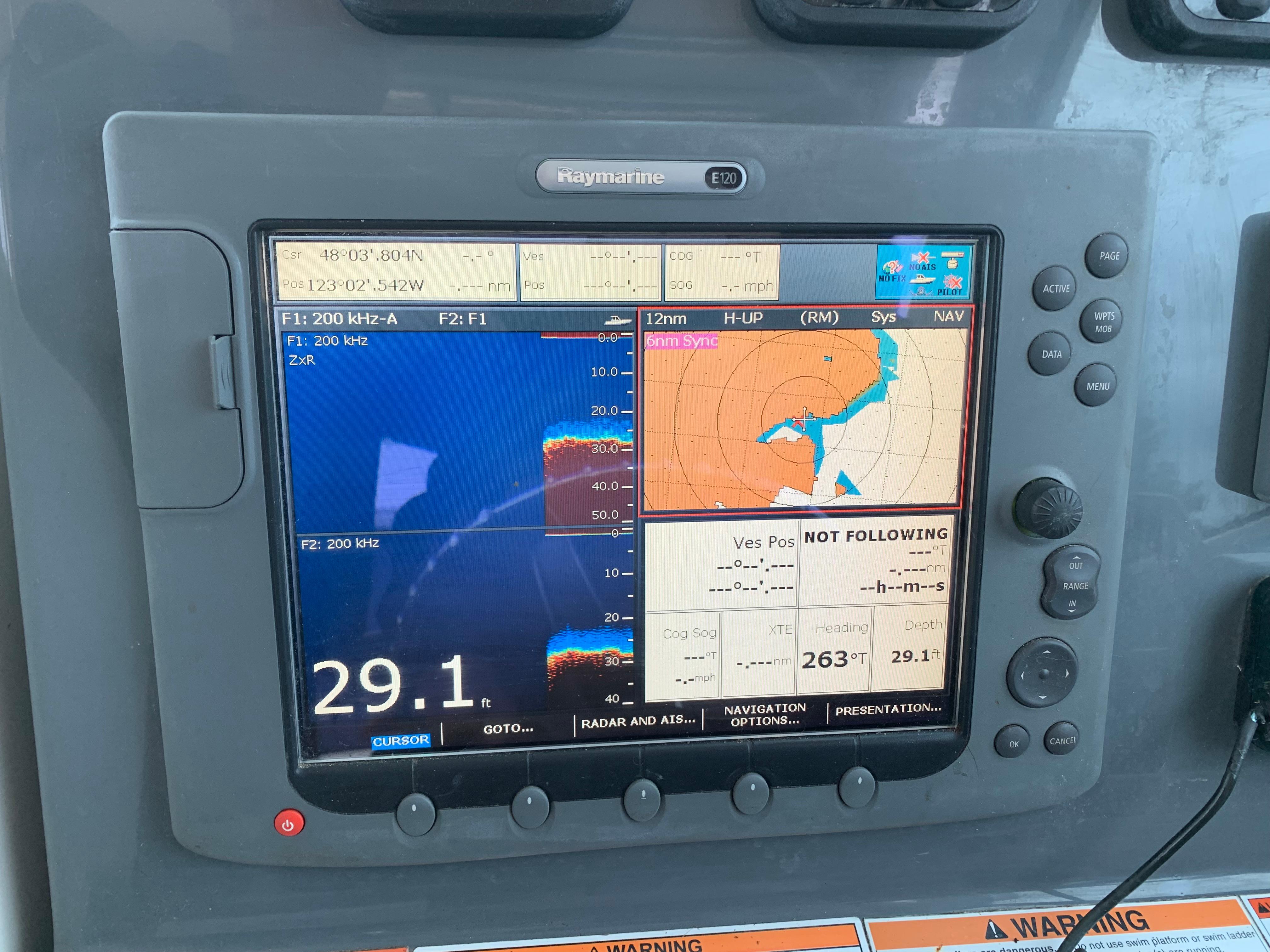 Close-up of a 2007 Pursuit OS 335 boat navigation system displaying sonar and map data.