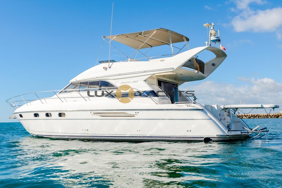 Luxury 1996 Princess 440 yacht on calm water under blue sky.