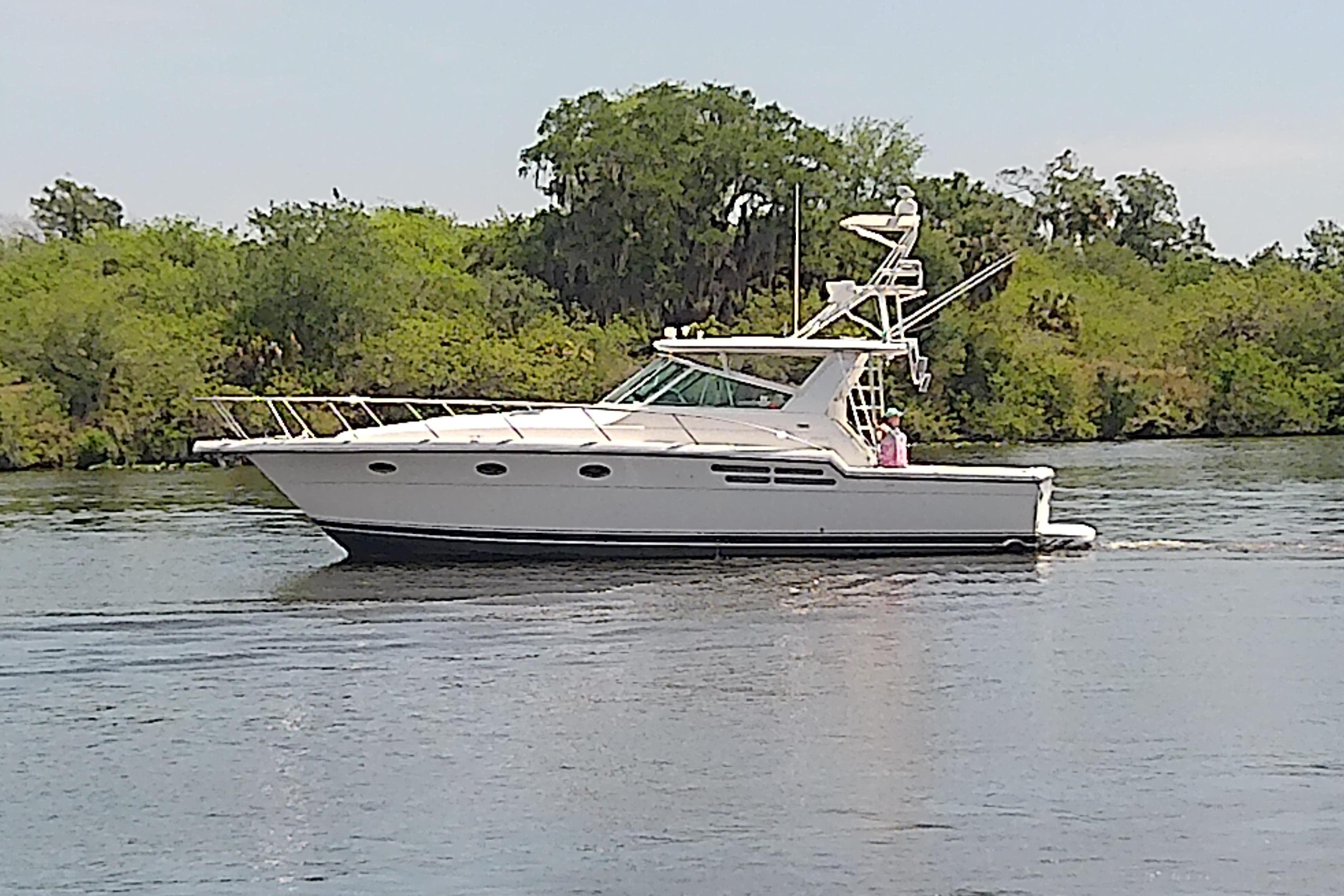 2000 Tiara Yachts 4100 Open cruising on a calm river with lush greenery.