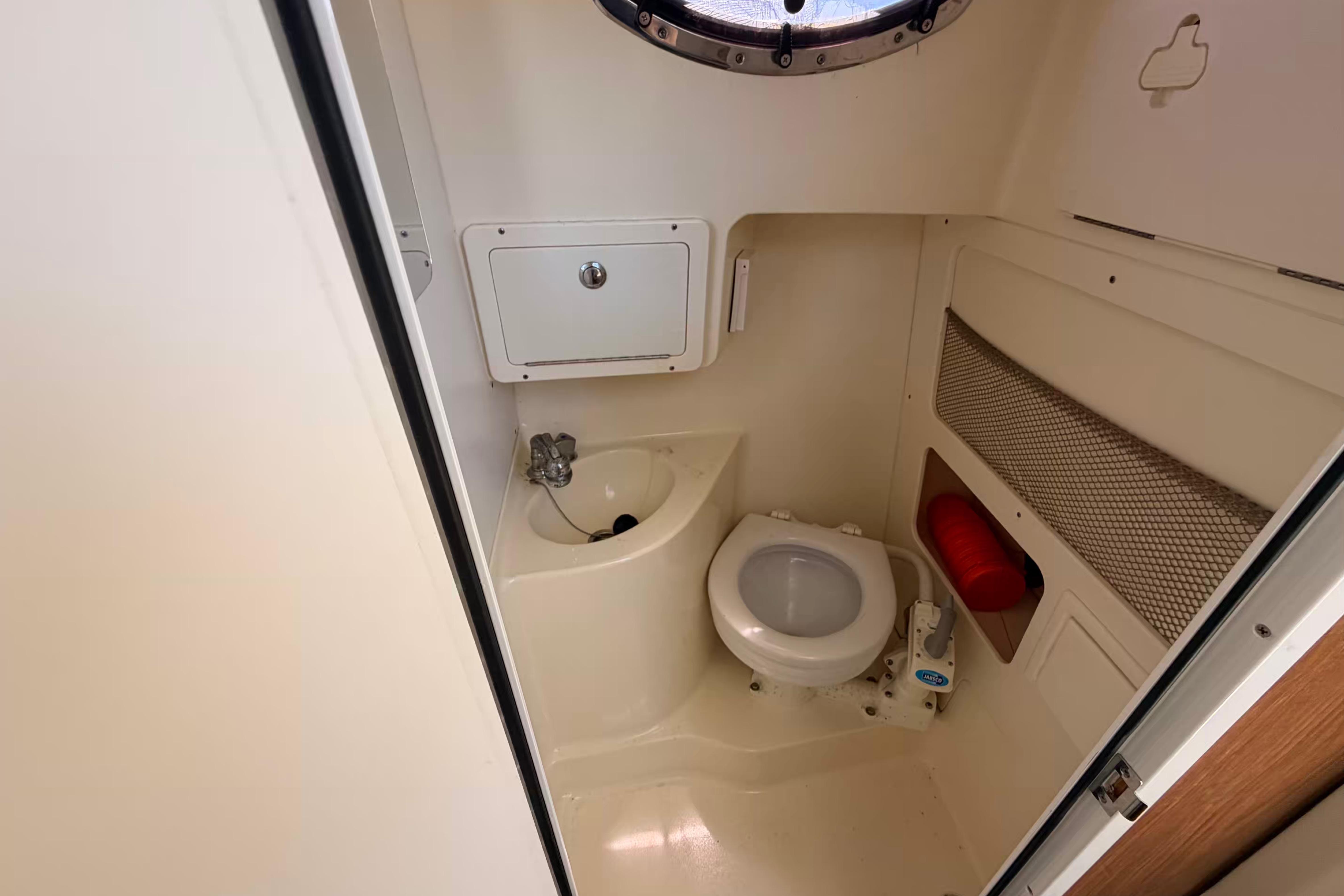 Compact bathroom in 2007 Scout 262 Abaco boat with toilet and sink.