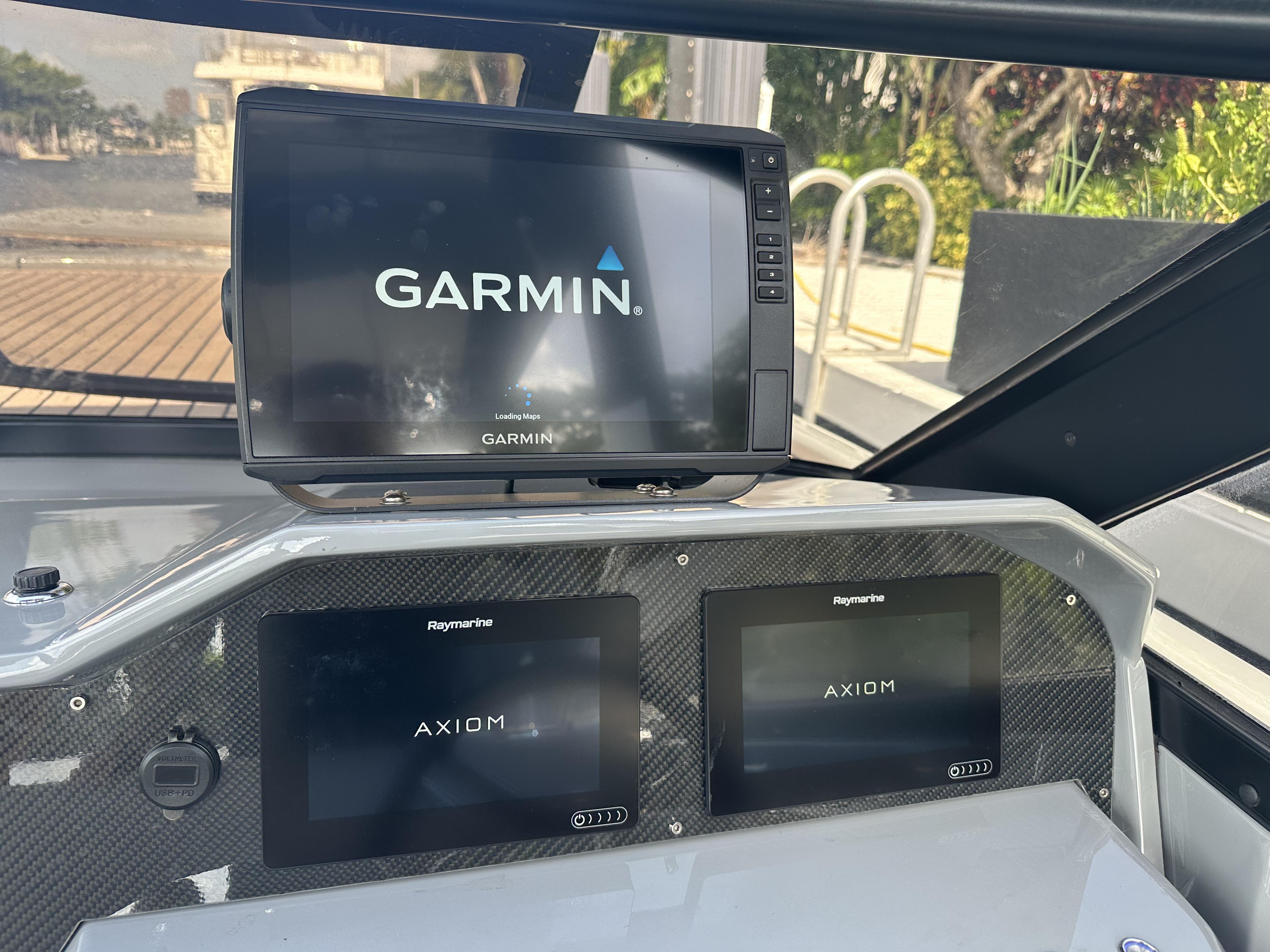 Dashboard of a 2021 Rand Leisure boat with Garmin and Raymarine Axiom displays.