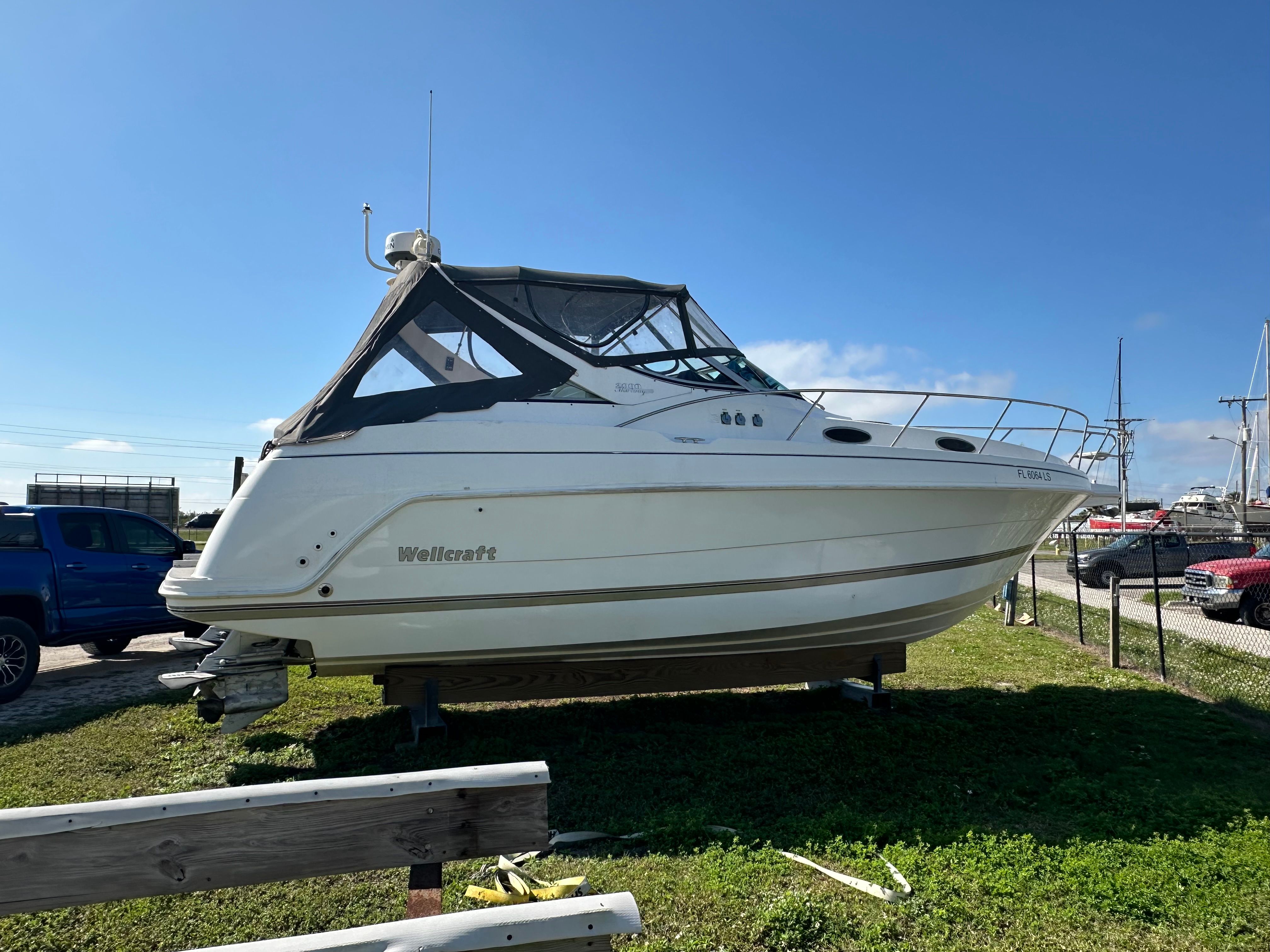 1999 Wellcraft 3000 Martinique boat parked on grass.