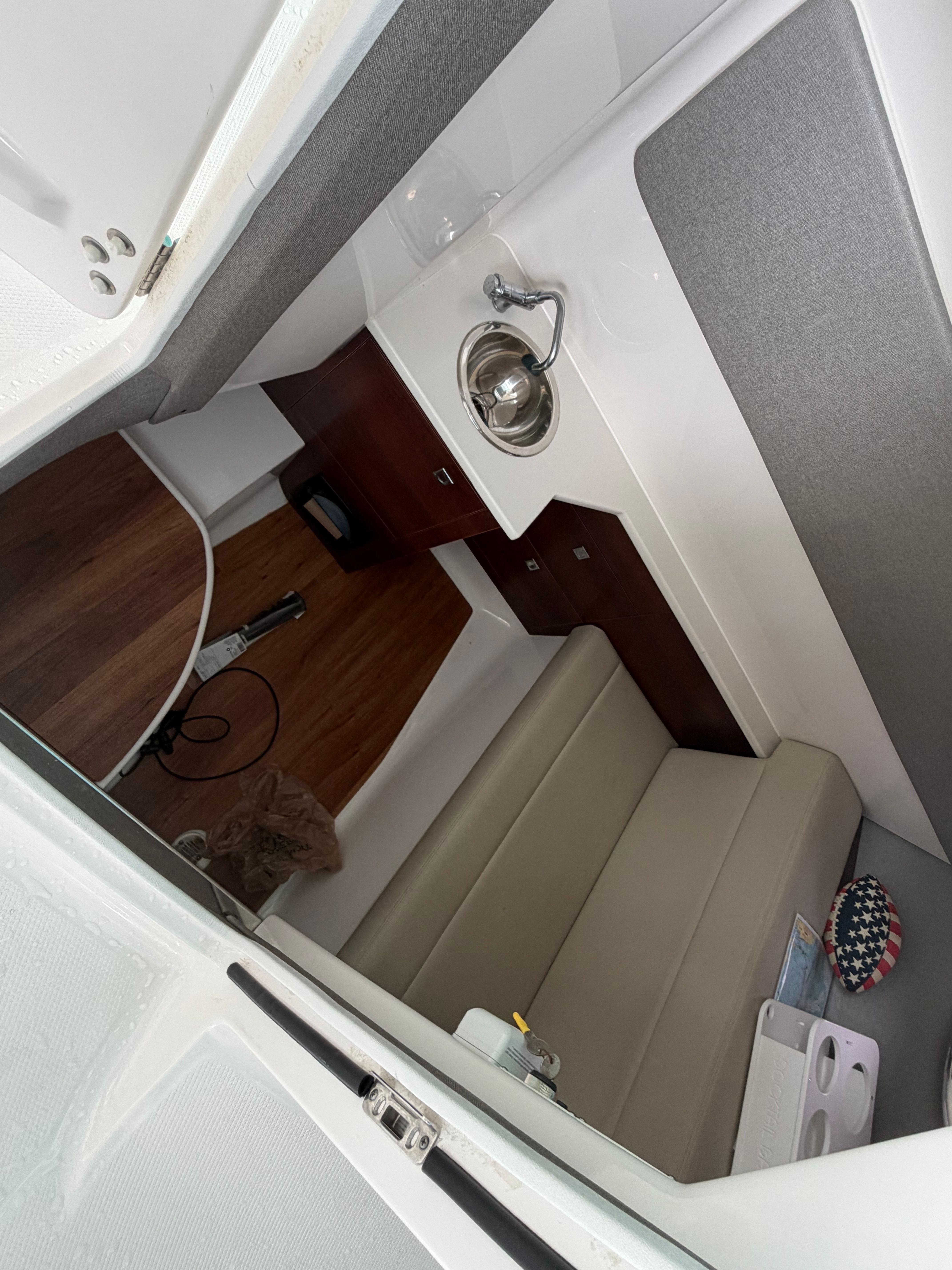 Interior of a modern yacht with a gray sofa and sink.