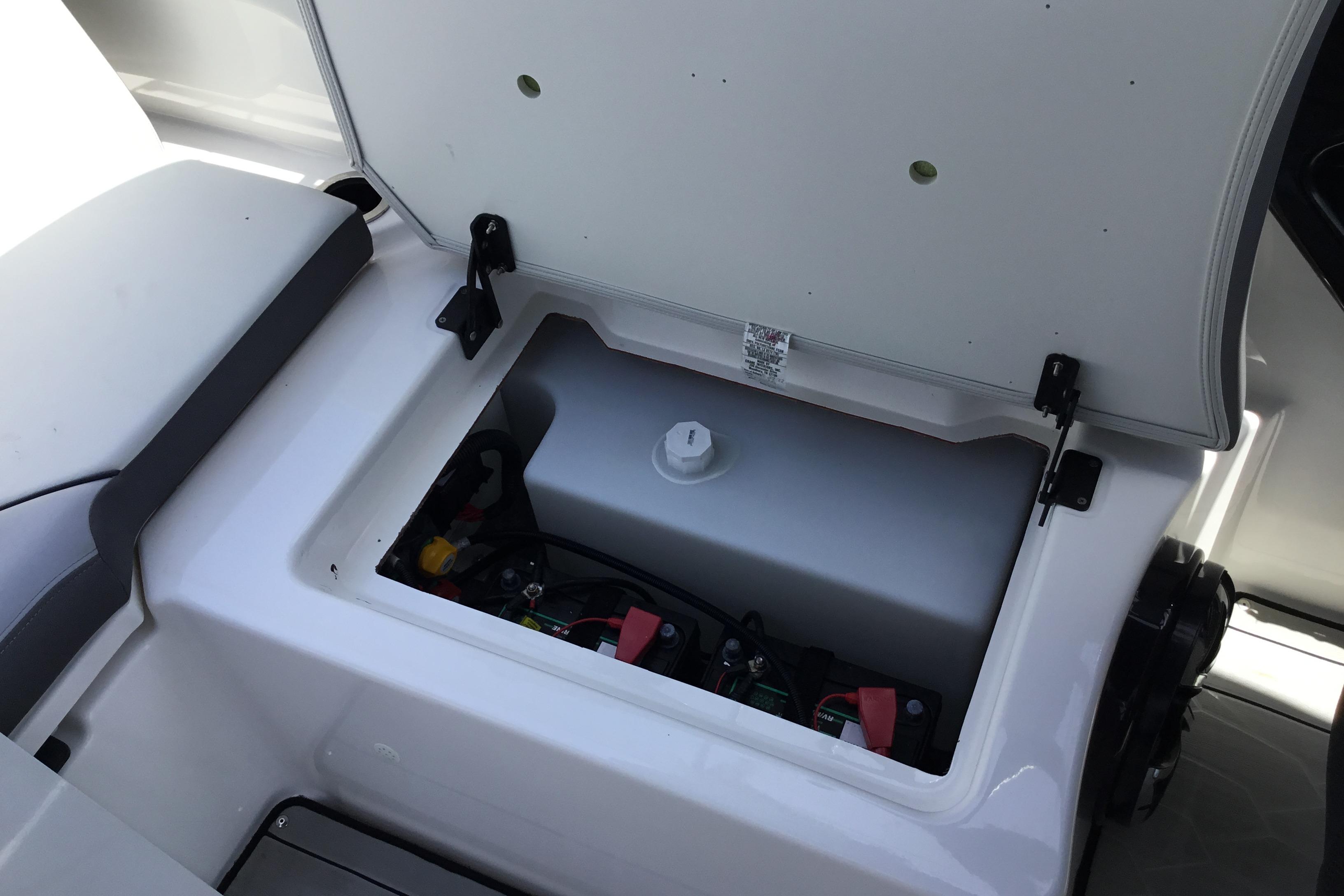 Open storage compartment in 2023 Yamaha Boats 252XE, showcasing interior components.