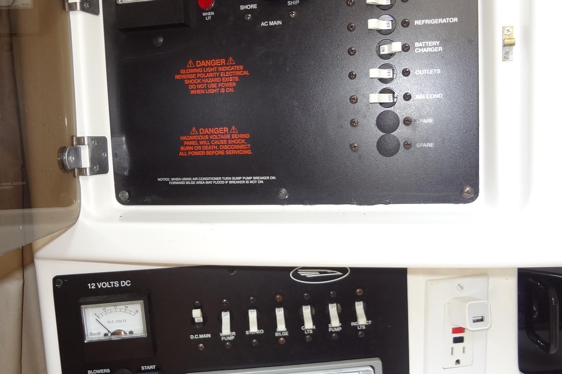 Electrical control panel on a 2000 Chaparral Signature 260 boat, featuring switches and warnings.