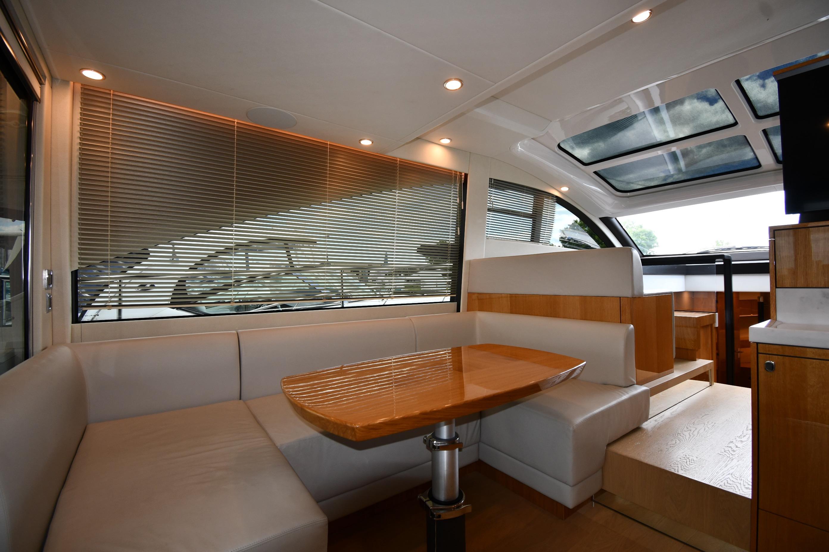 Luxurious interior of 2024 Fairline G50 Targa yacht with elegant seating and wooden table.