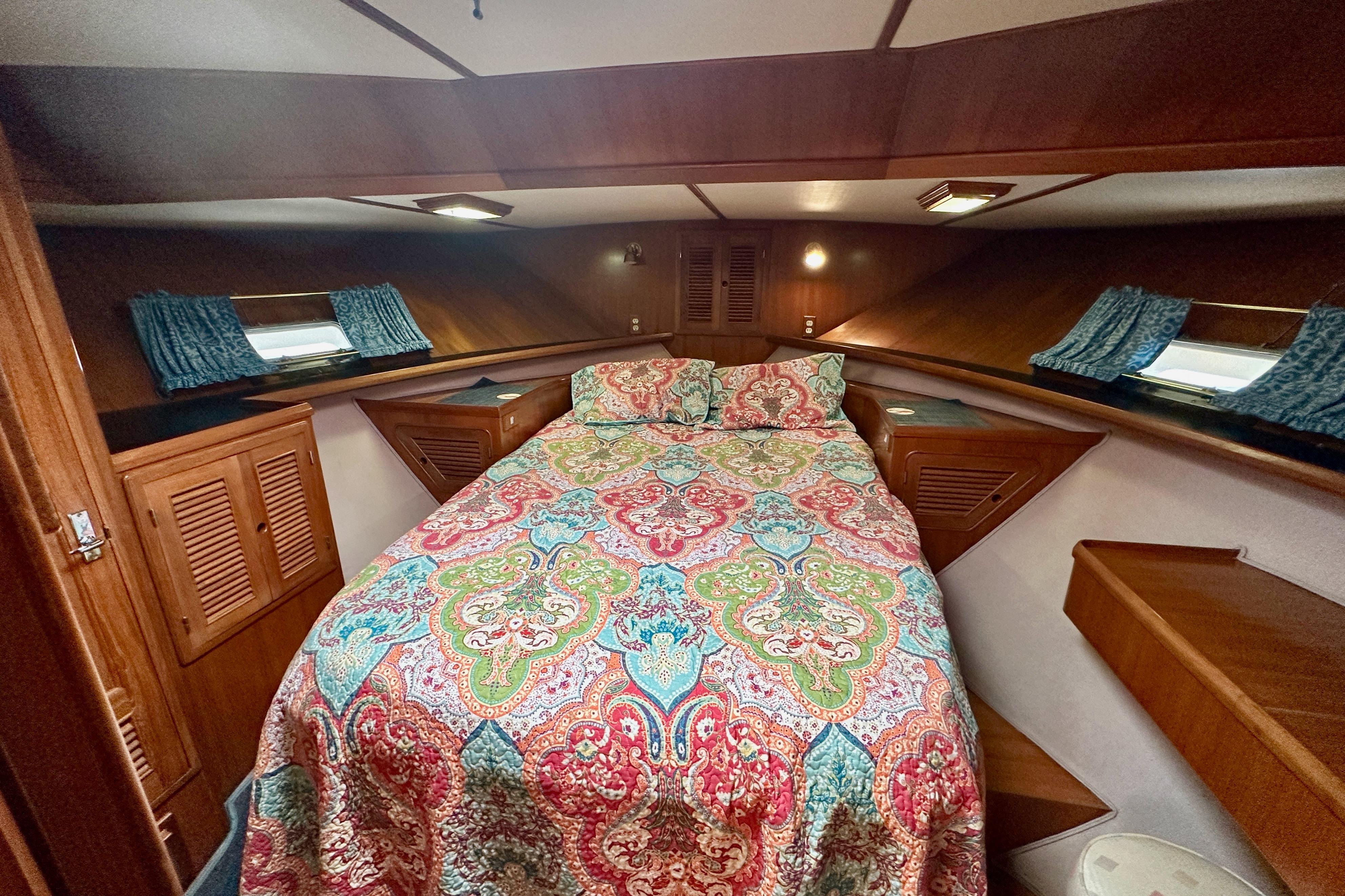 Cozy cabin interior of 1986 Kha Shing Spindrift 46 yacht with colorful bedding.