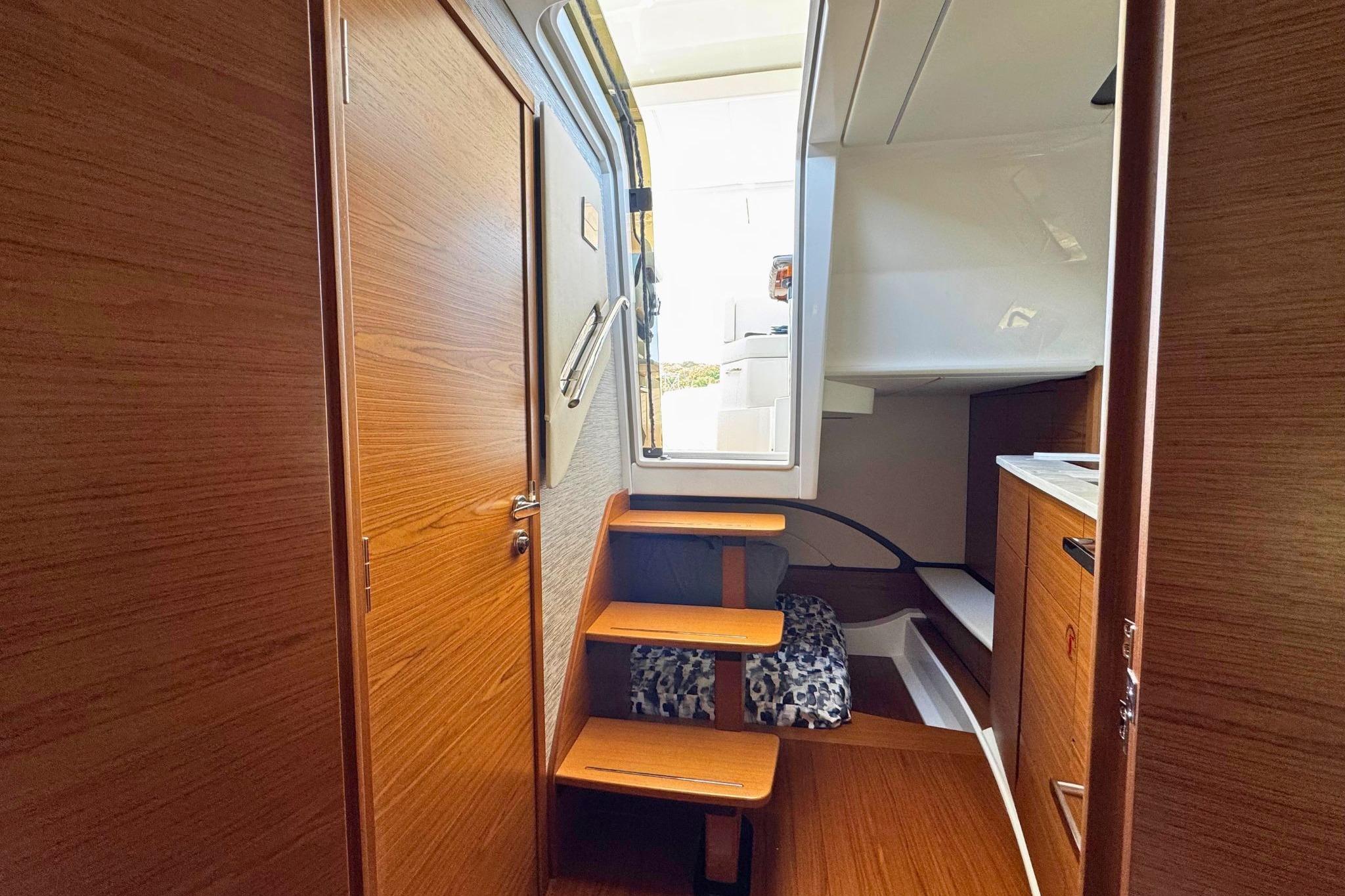 Interior view of 2027 Tiara Yachts 39 LE, featuring wooden stairs and cabinetry.