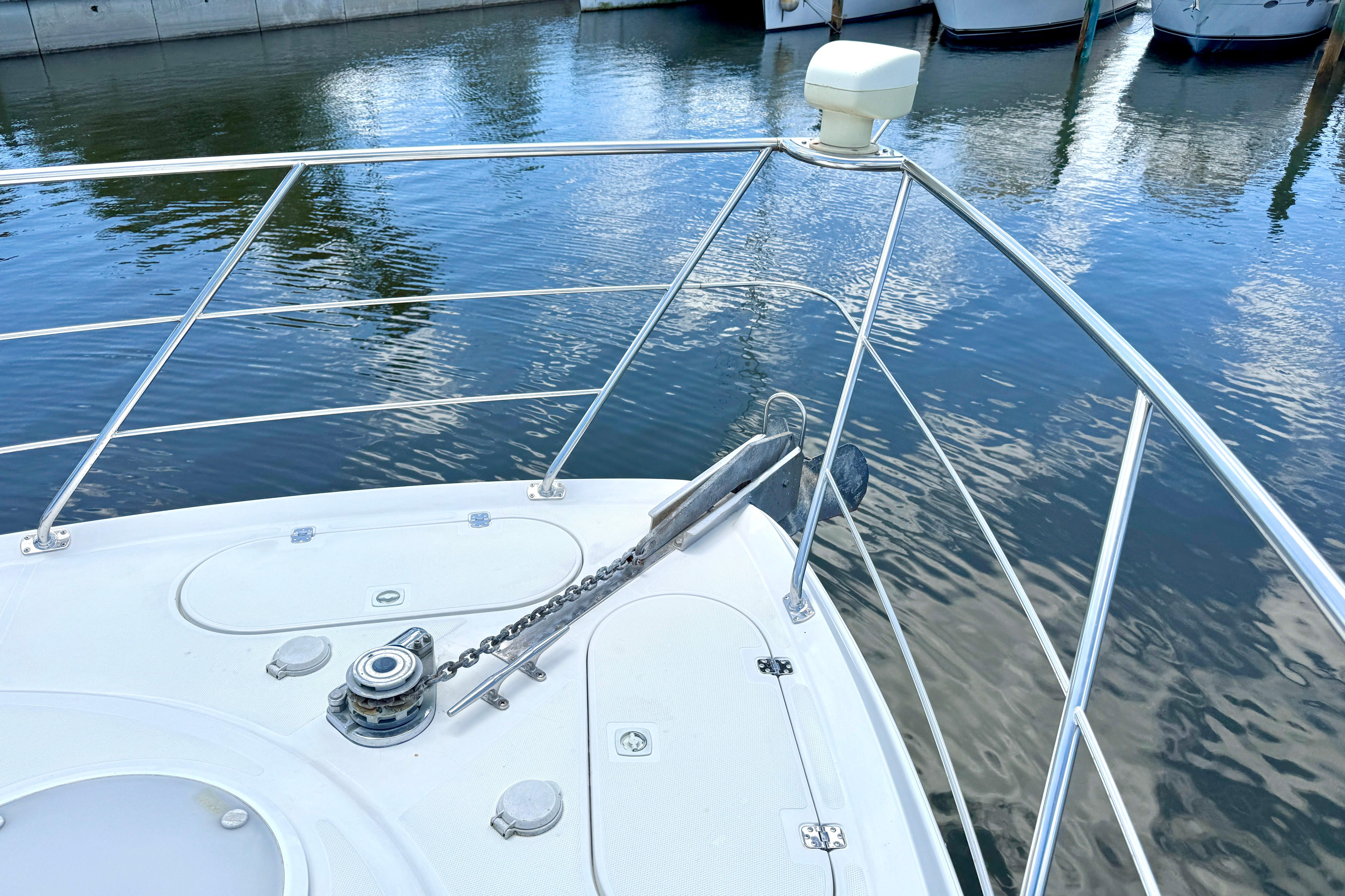 Bow of 1999 Carver 450 Voyager Pilothouse yacht with anchor and railing.
