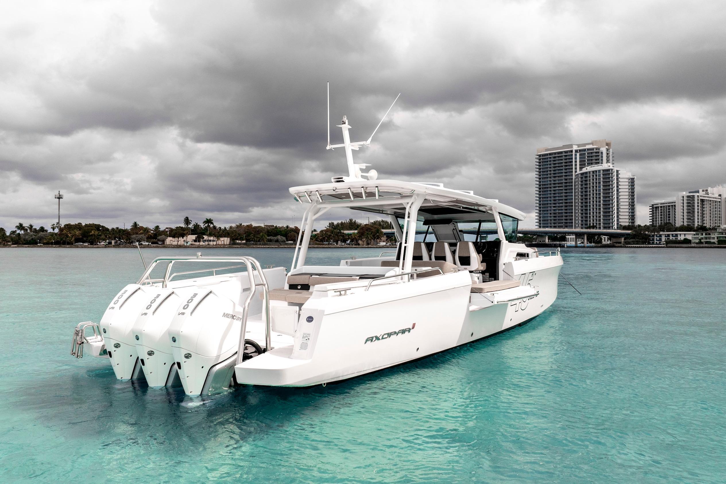 2025 Axopar 45 Cross Top boat on turquoise water with cloudy sky backdrop.