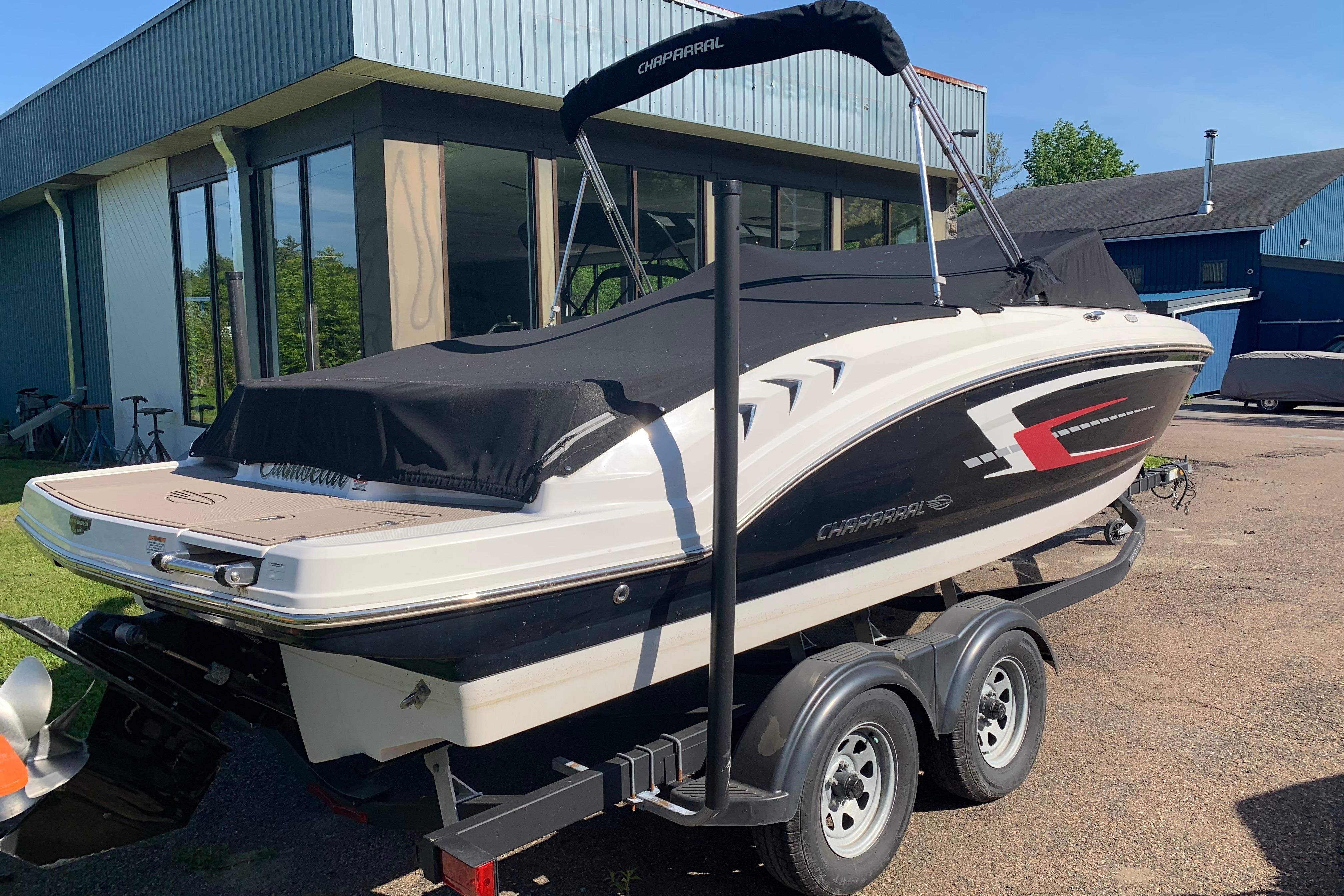 2022 Chaparral 23 SSi boat on trailer, parked outside a building.
