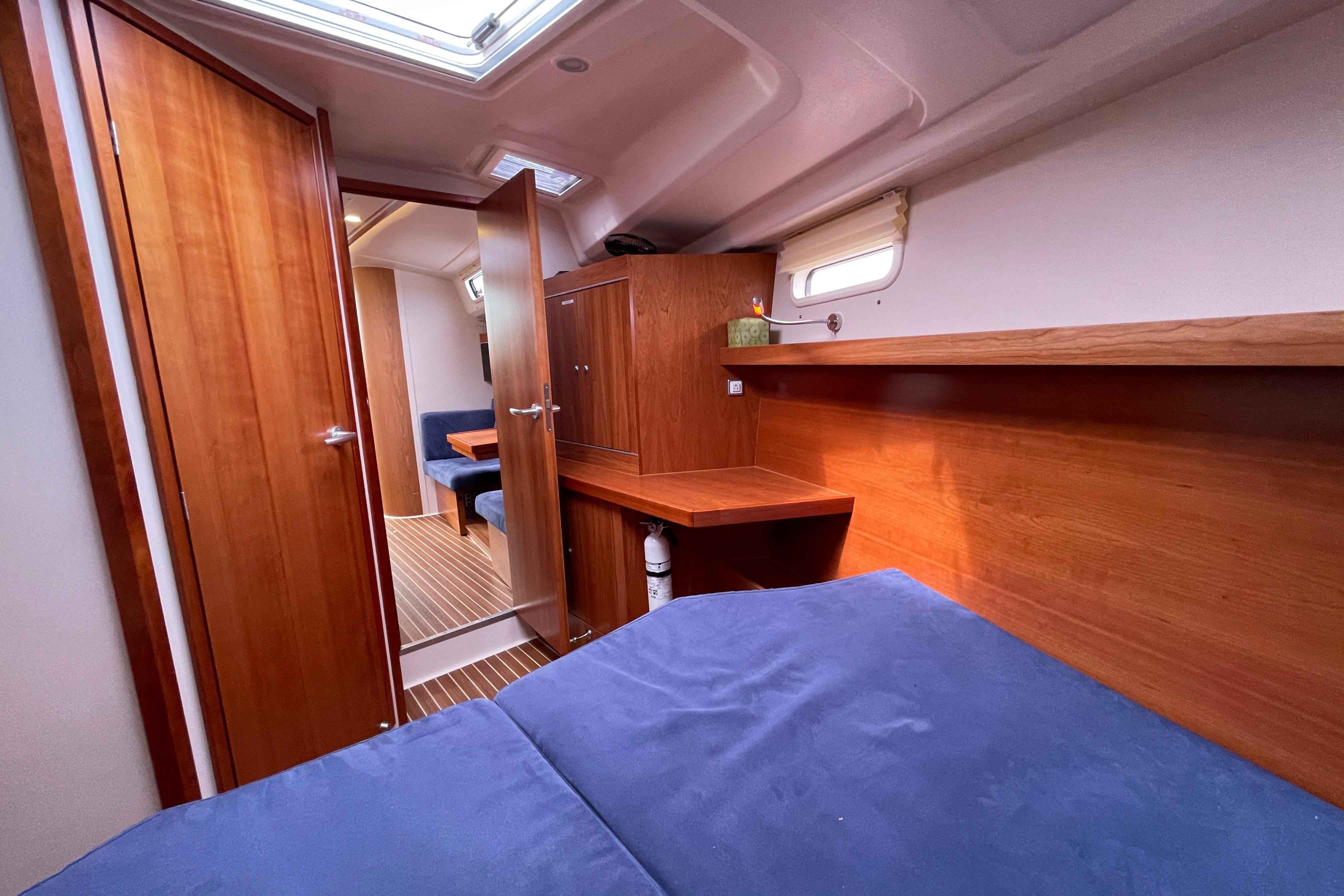 Interior of 2014 Hanse 415 yacht cabin with wooden furnishings and blue bedding.