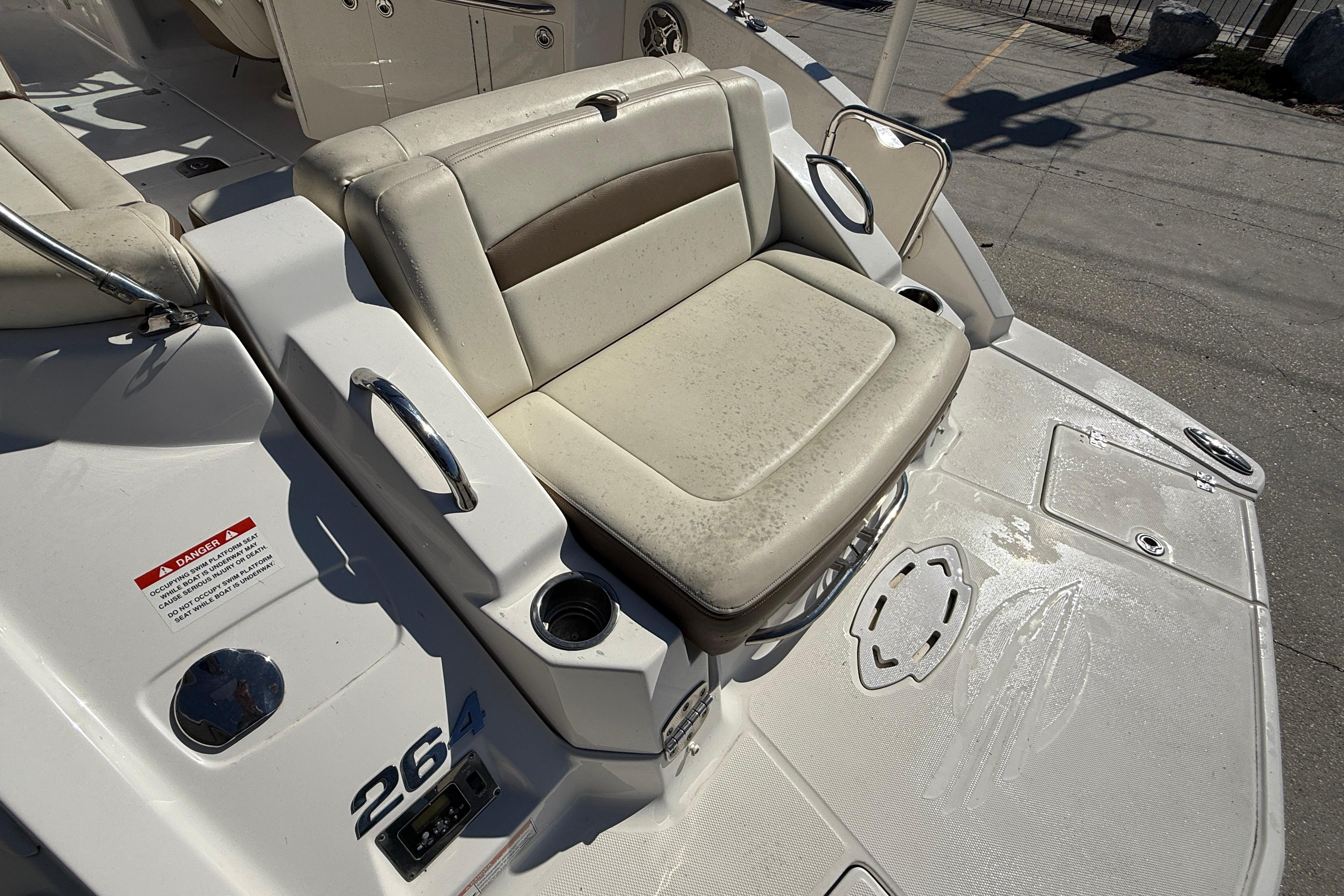 2014 Chaparral 264 Sunesta boat seat with cup holders and safety warning label.