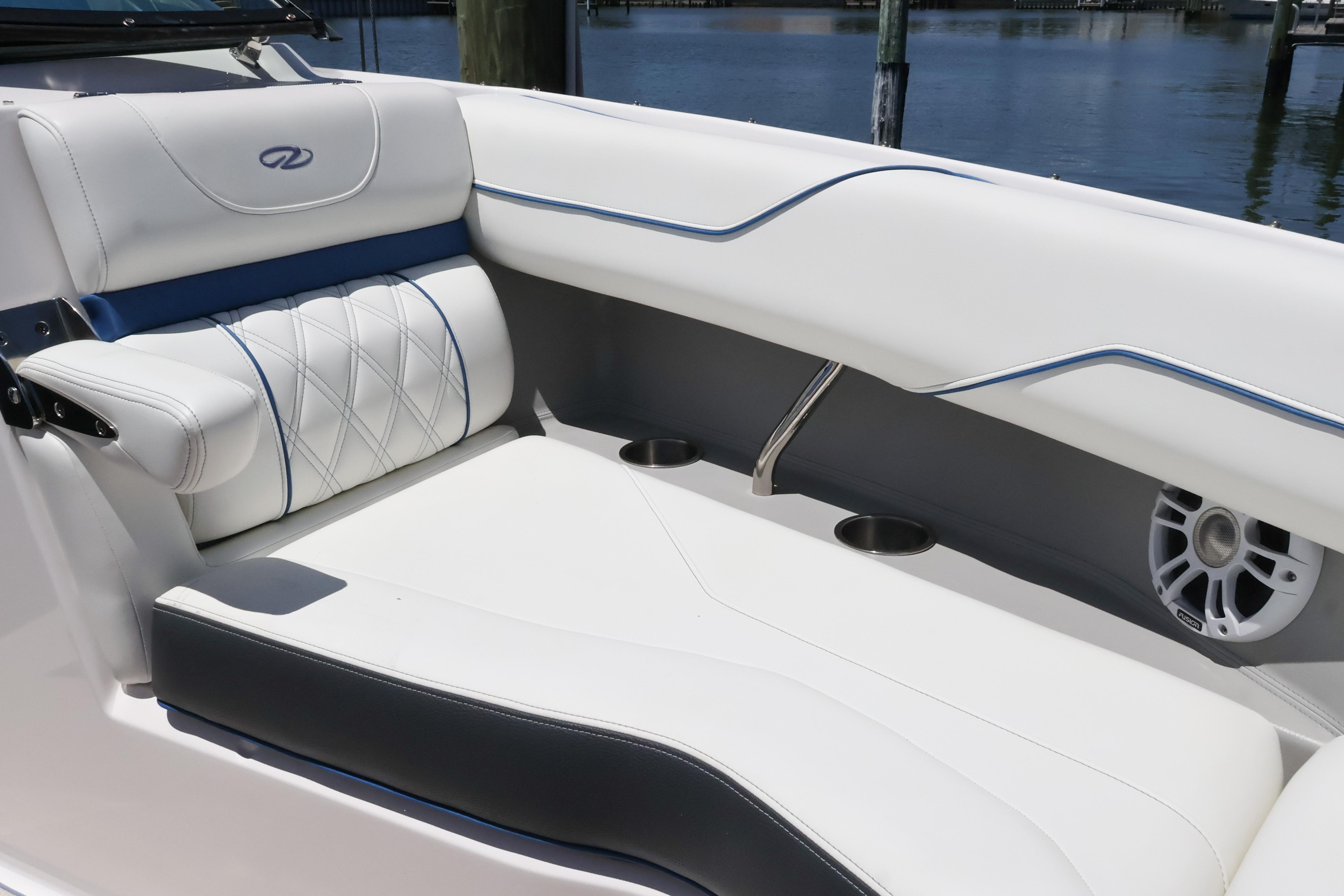 Luxurious seating on a 2020 Regal LX4 boat, featuring white upholstery and cup holders.