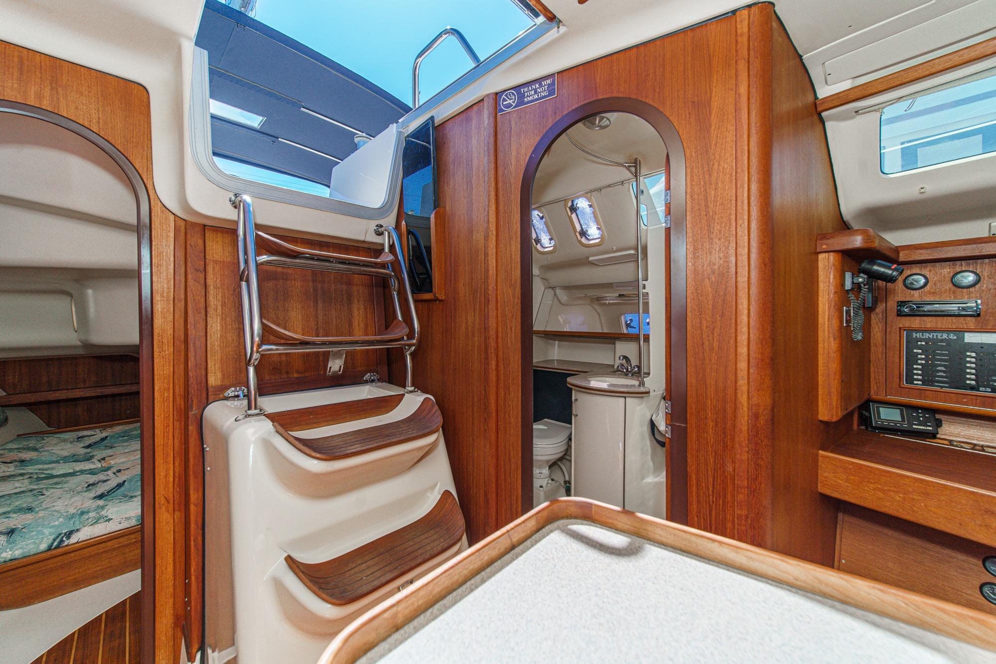 Interior of a 1996 Hunter 376 sailboat featuring wood paneling and compact amenities.