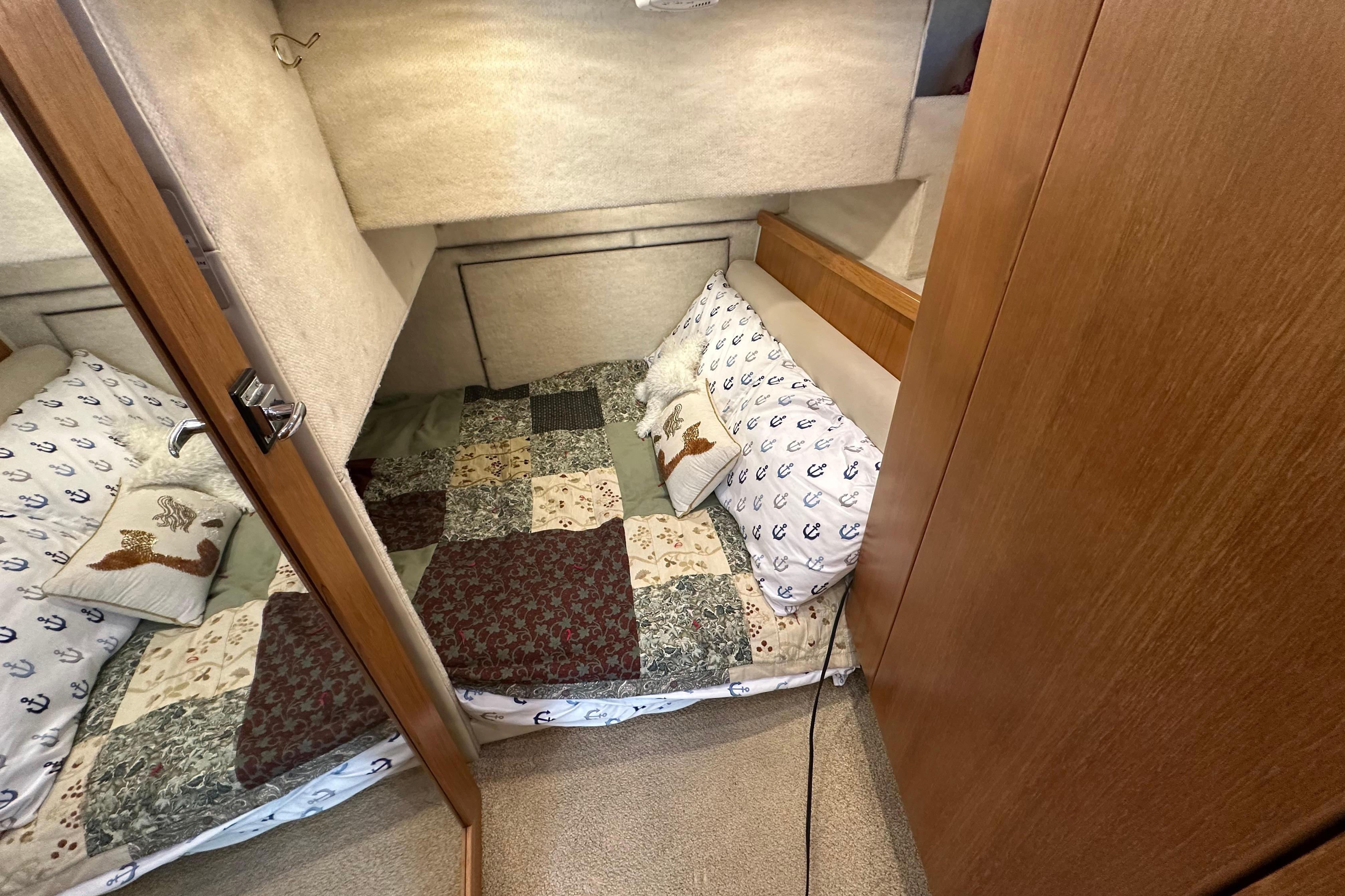 Cozy cabin bedroom in 2000 Bayliner 4087 Aft Cabin Motoryacht with nautical-themed bedding.
