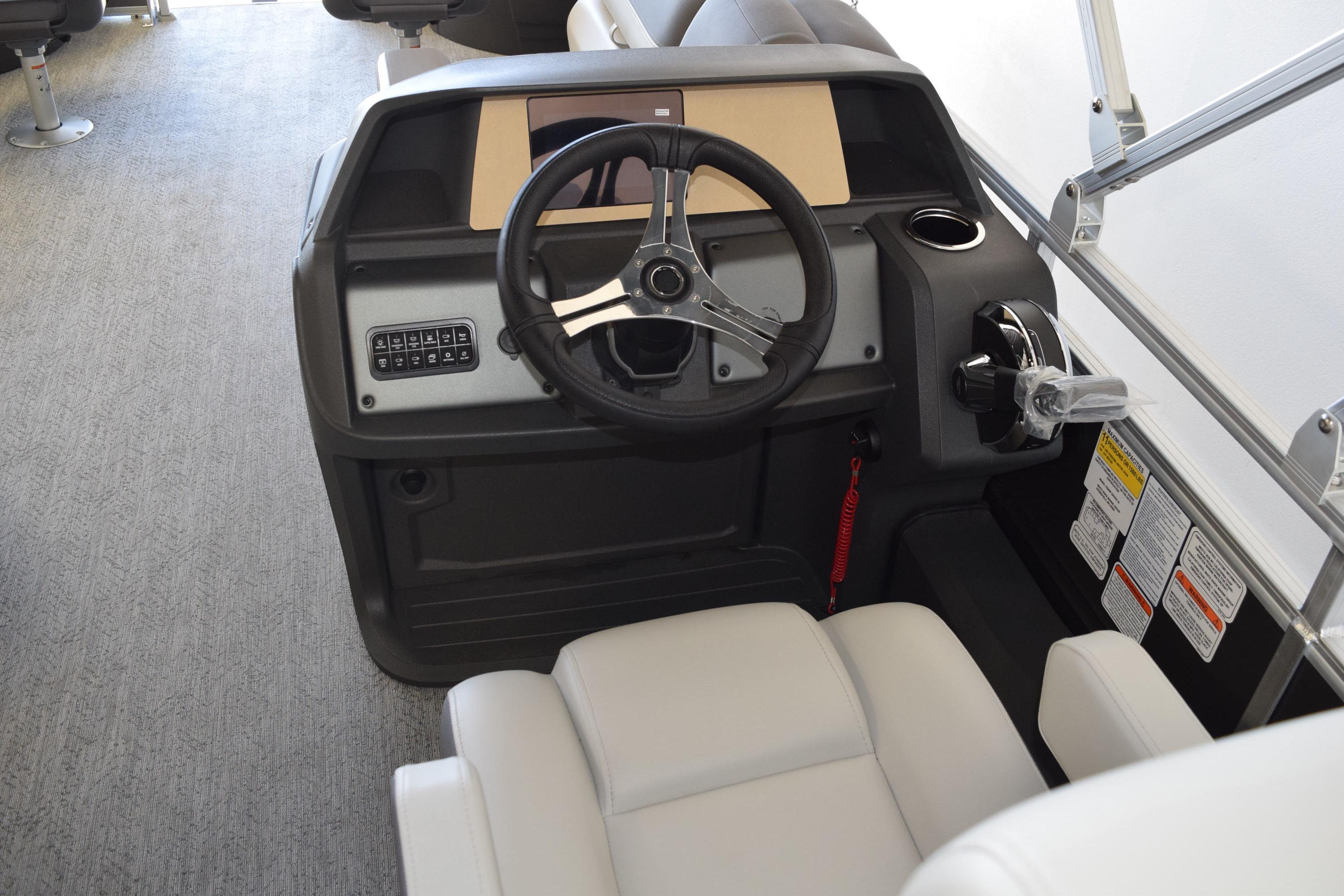 2026 Sun Tracker Fishin' Barge 22 DLX helm with steering wheel and controls.