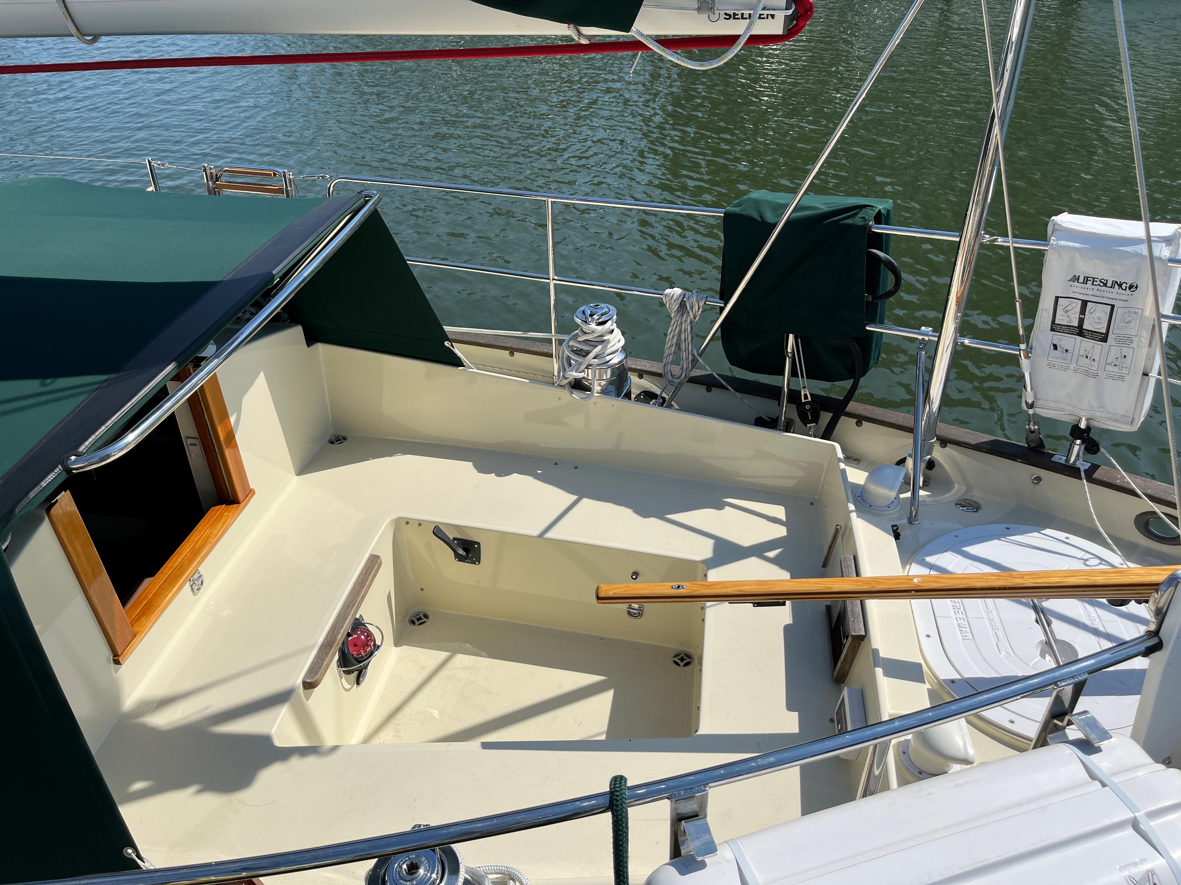 Sailboat cockpit of 2016 Alajuela 38, featuring green canopy and wooden accents.