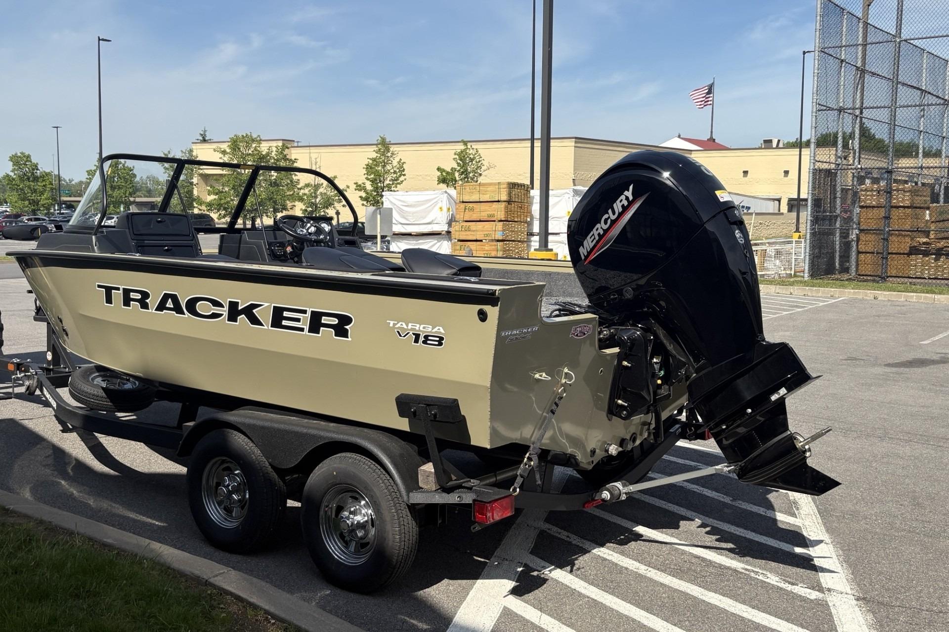 2026 Tracker Targa V-18 Combo boat with Mercury engine in parking lot.