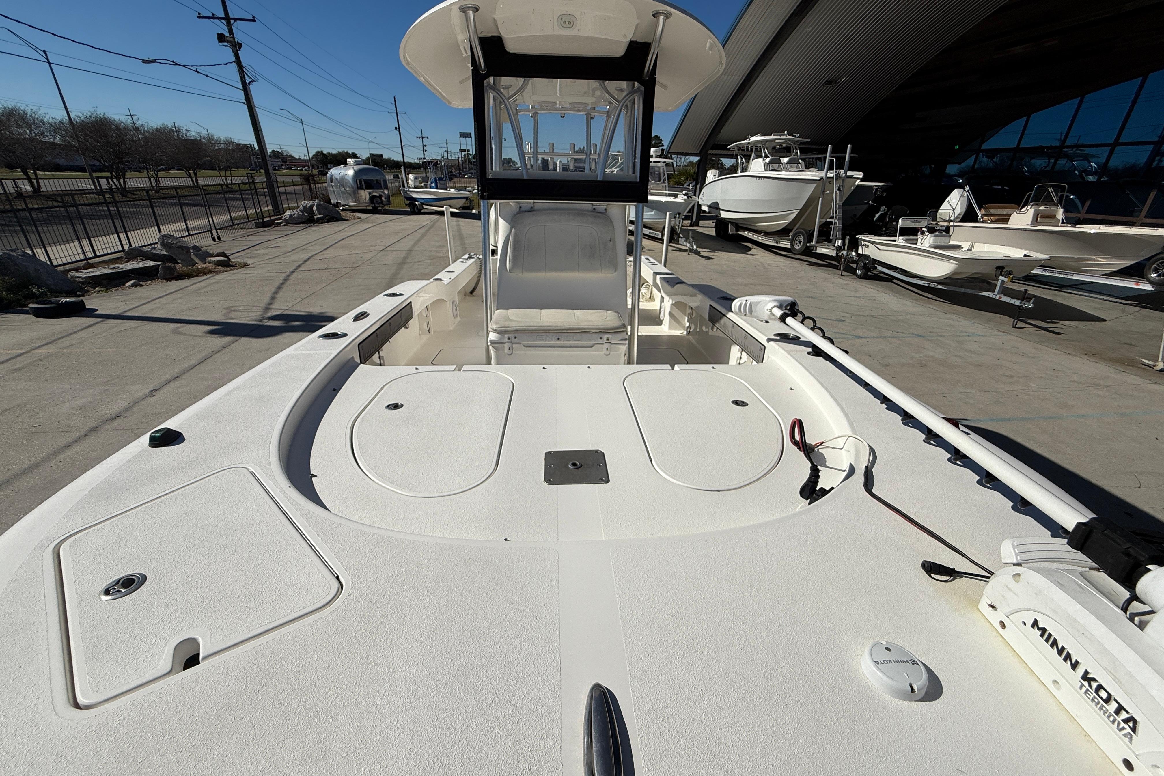 2020 Tideline 235 Hybrid boat, spacious deck, docked outdoors, featuring Minn Kota trolling motor.