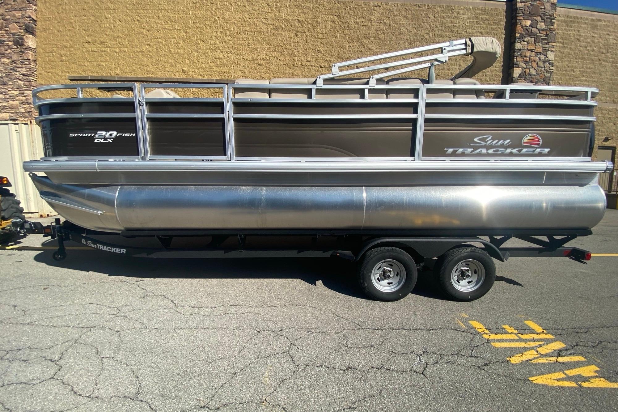 2025 Sun Tracker SportFish 20 DLX pontoon boat on trailer, side view.