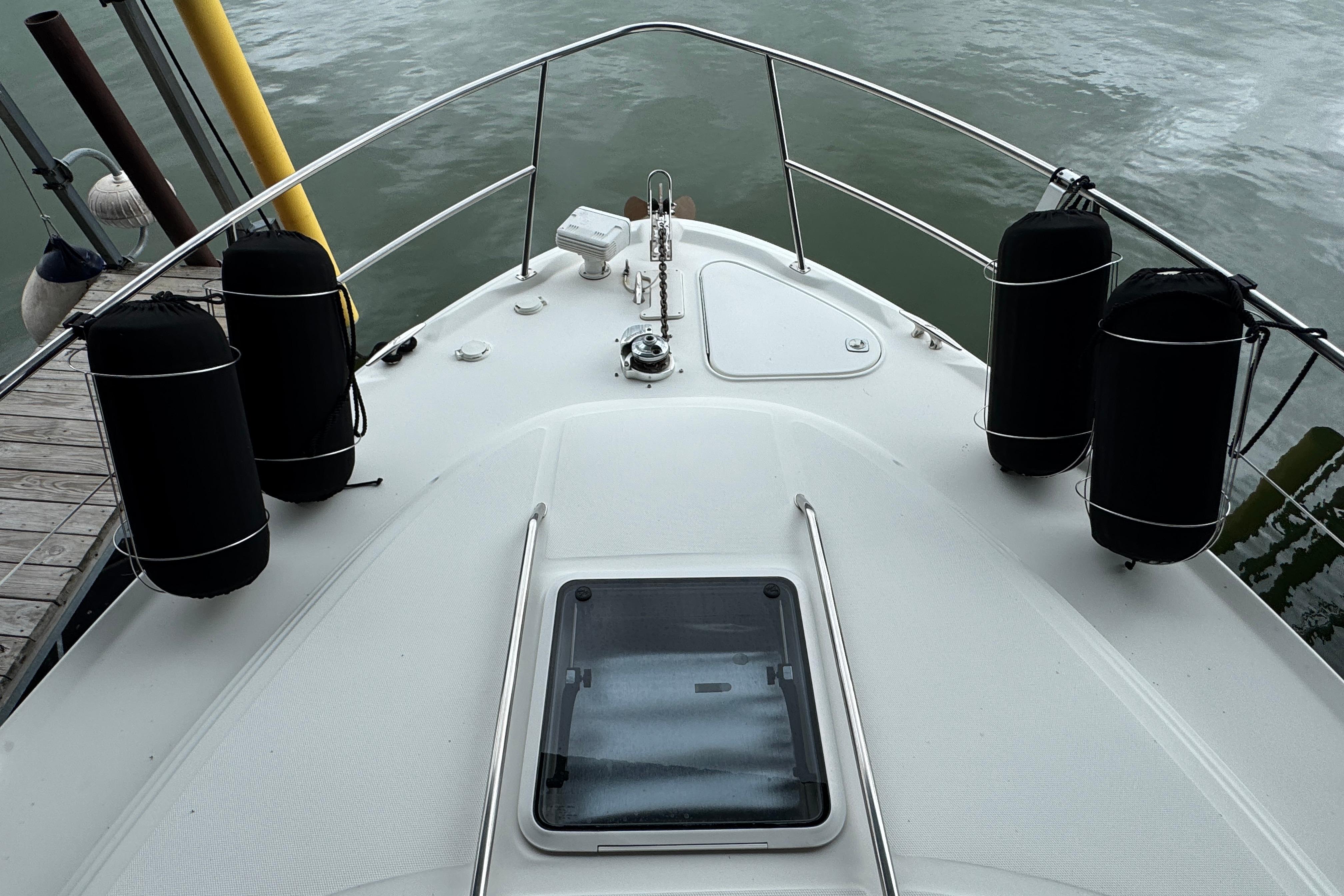 Bow view of 2001 Sea Ray 380 Sundancer yacht with fenders and hatch.