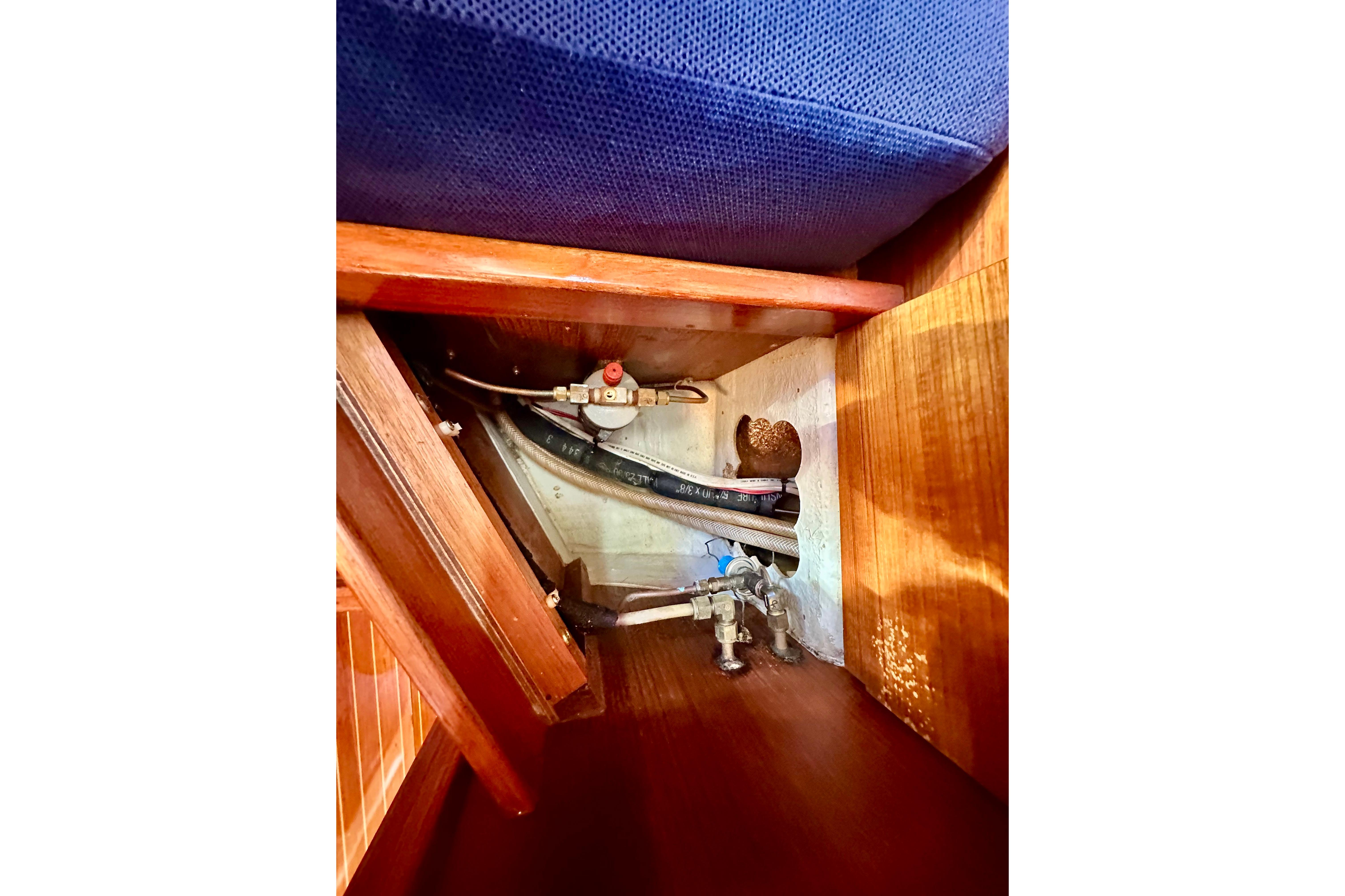 Interior view of 1984 Jonmeri 40 yacht showing plumbing and storage area.