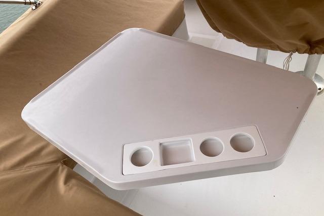 White table with cup holders on a 2000 Mainship 430 Trawler boat.
