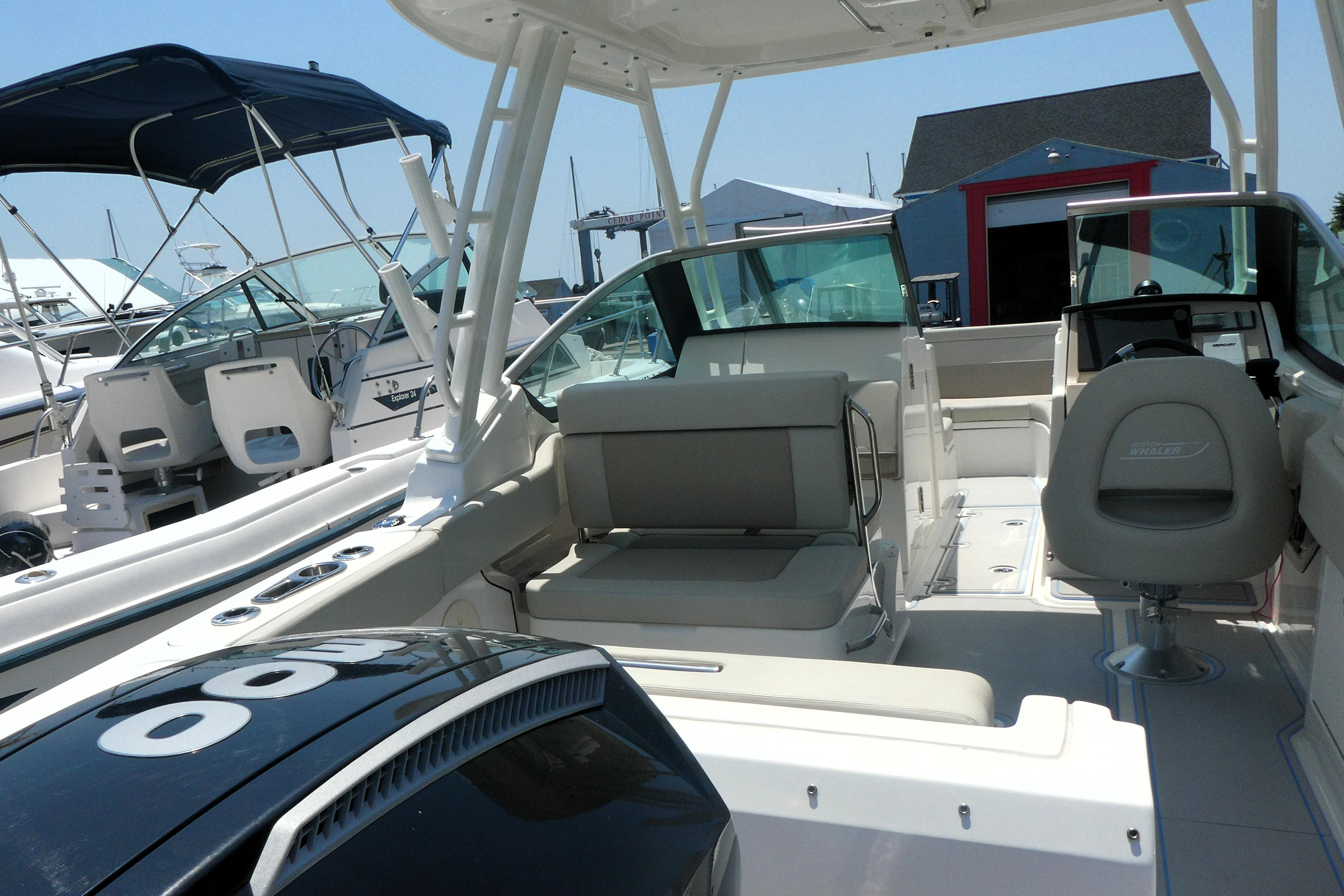 2022 Boston Whaler 240 Vantage boat interior with seating and helm, docked at marina.