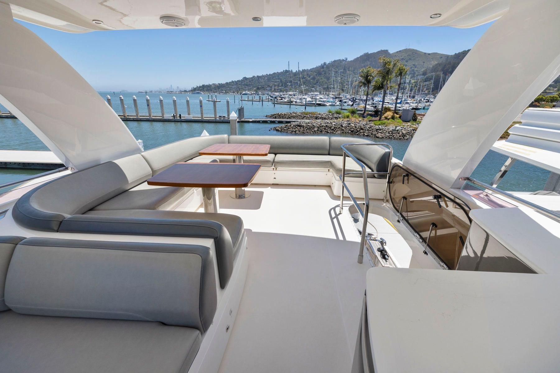 Luxurious 2015 Princess 60 Flybridge Motor Yacht with spacious seating and scenic marina view.