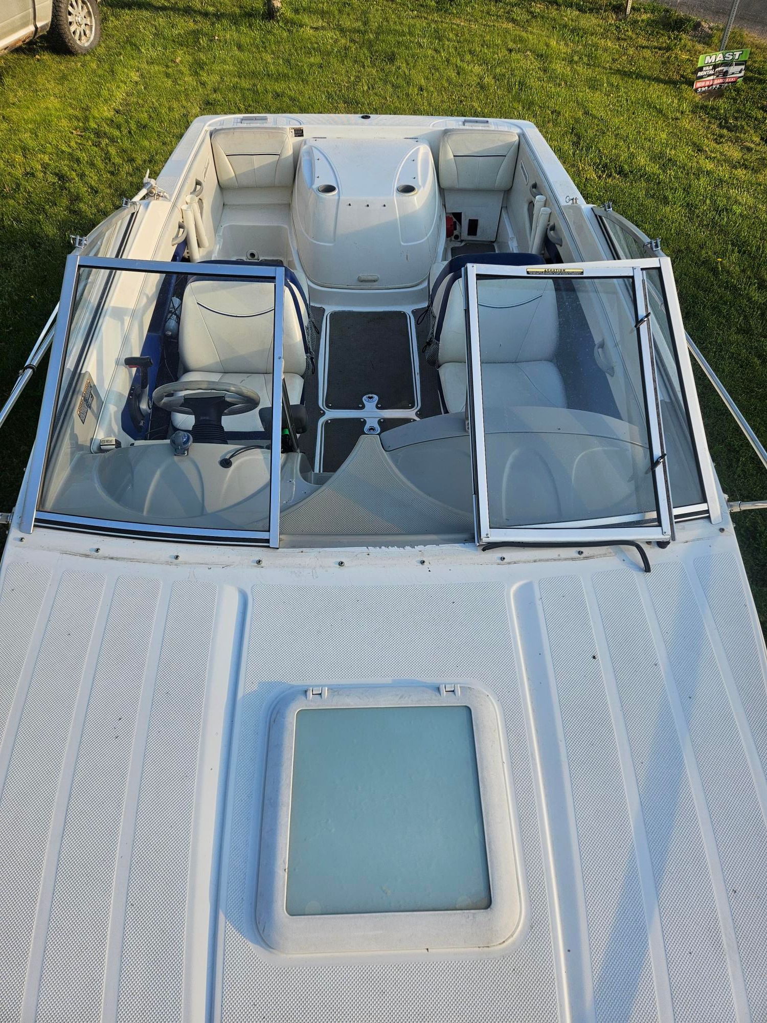 2006 Bayliner Cuddy Cab parked on green grass.