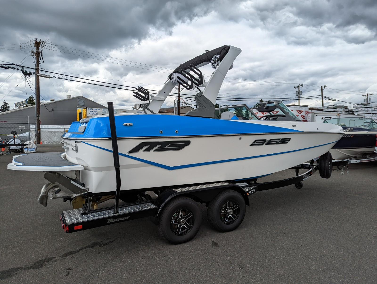 2022 MB B52-21 Classic boat on trailer, blue and white, side view.