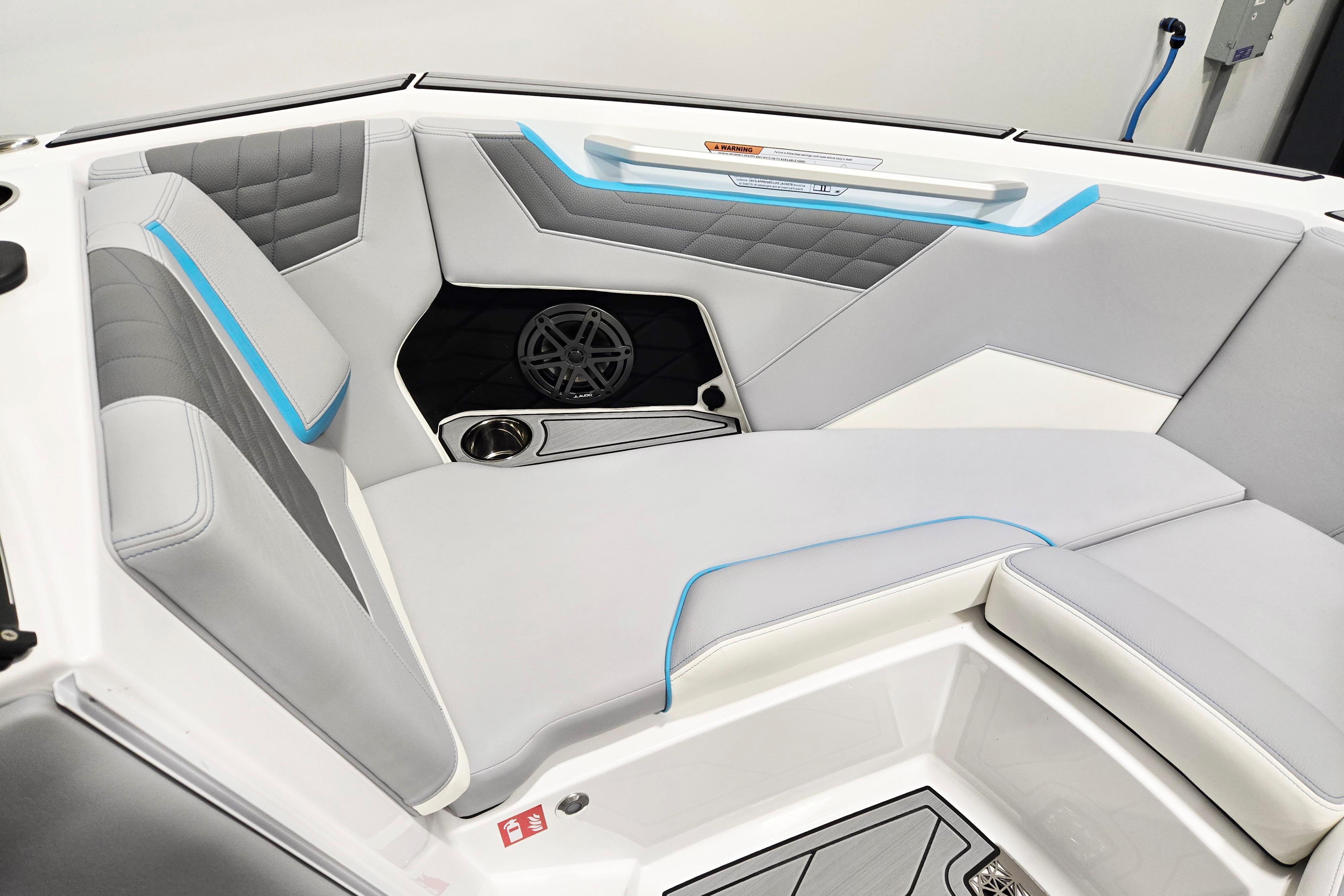 2026 Nautique Super Air Nautique S21 interior with gray and blue seating, cup holder, and speaker.